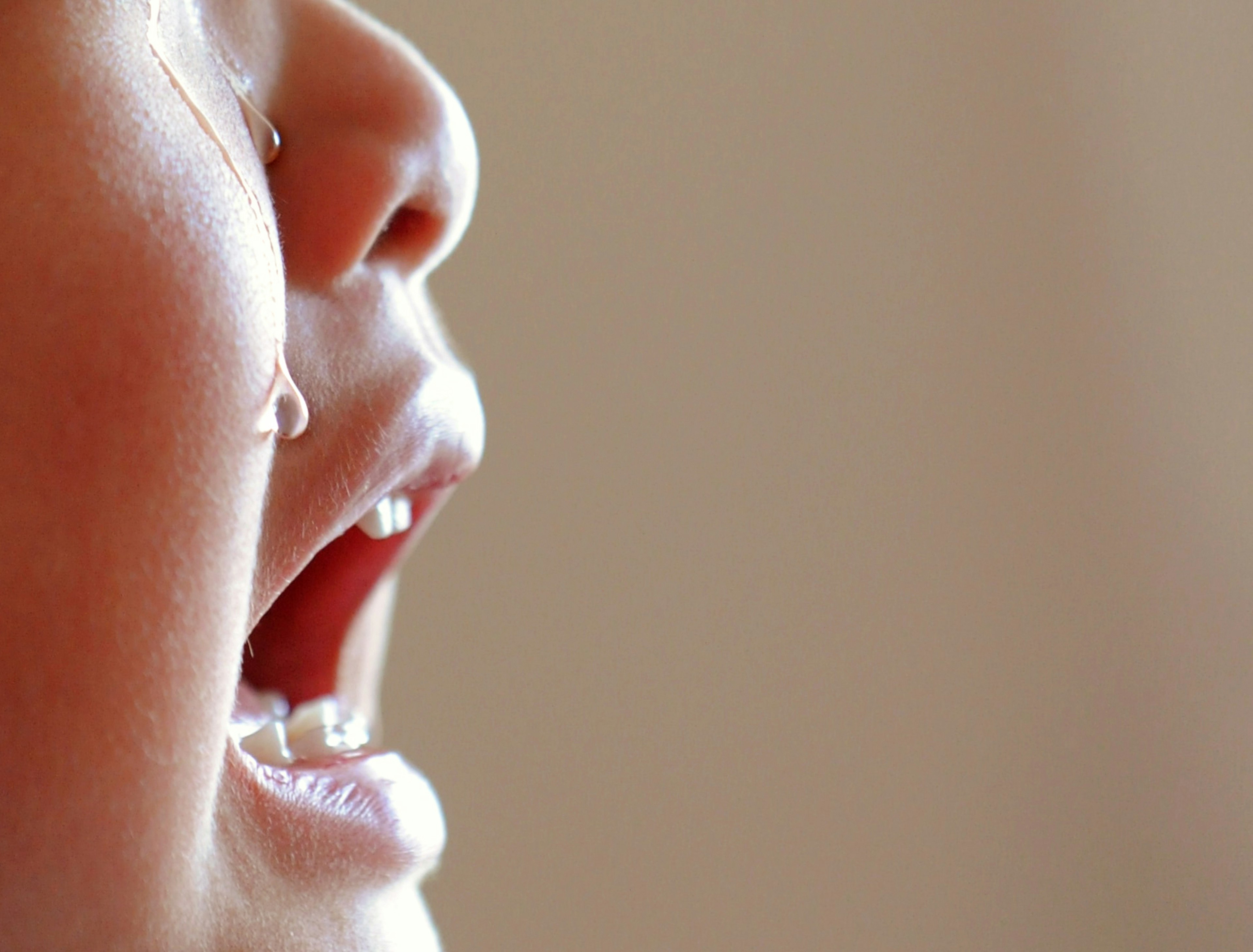 Profile of a crying child with a tear rolling down their cheek