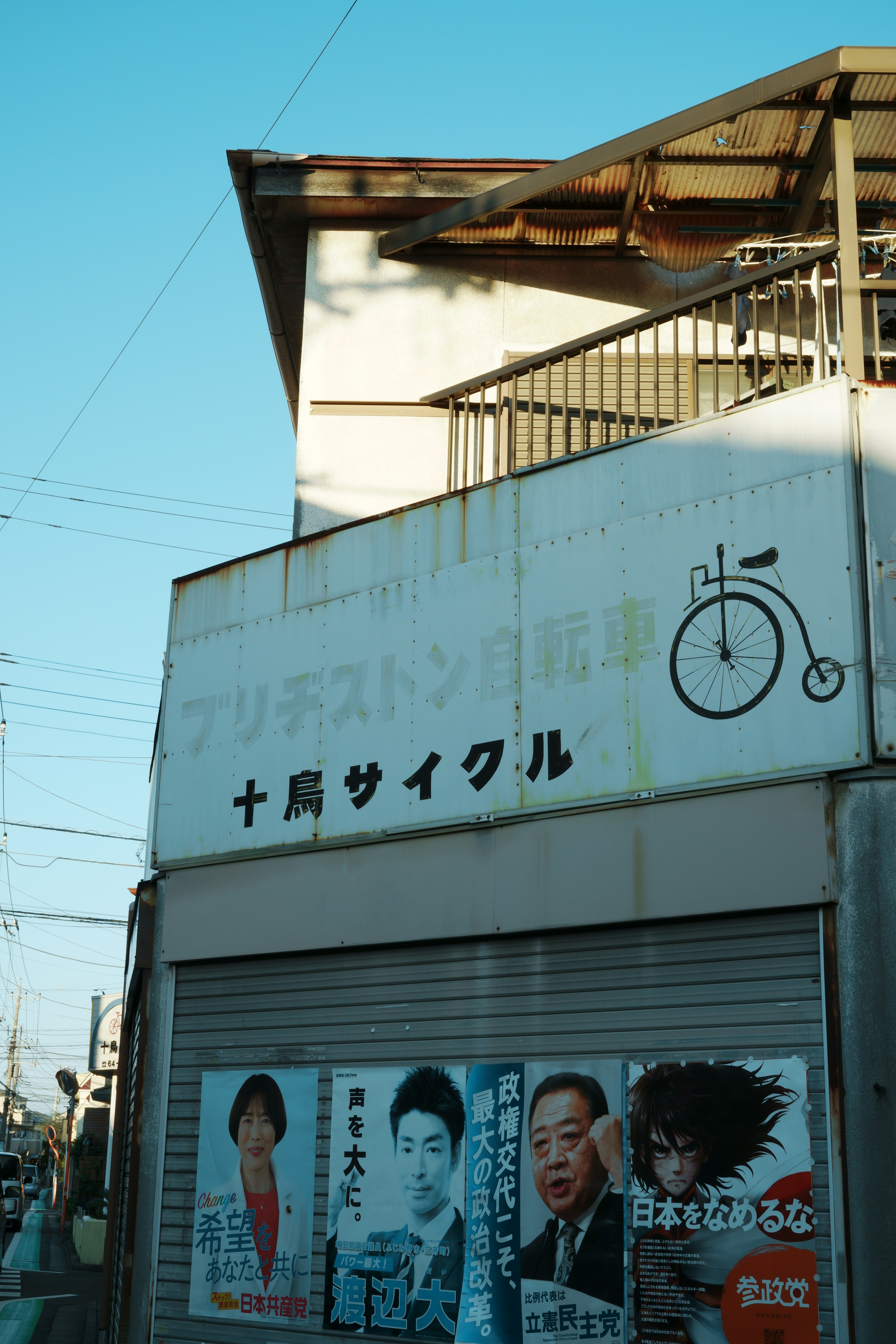 自転車店の看板とポスターが並ぶ街角の風景