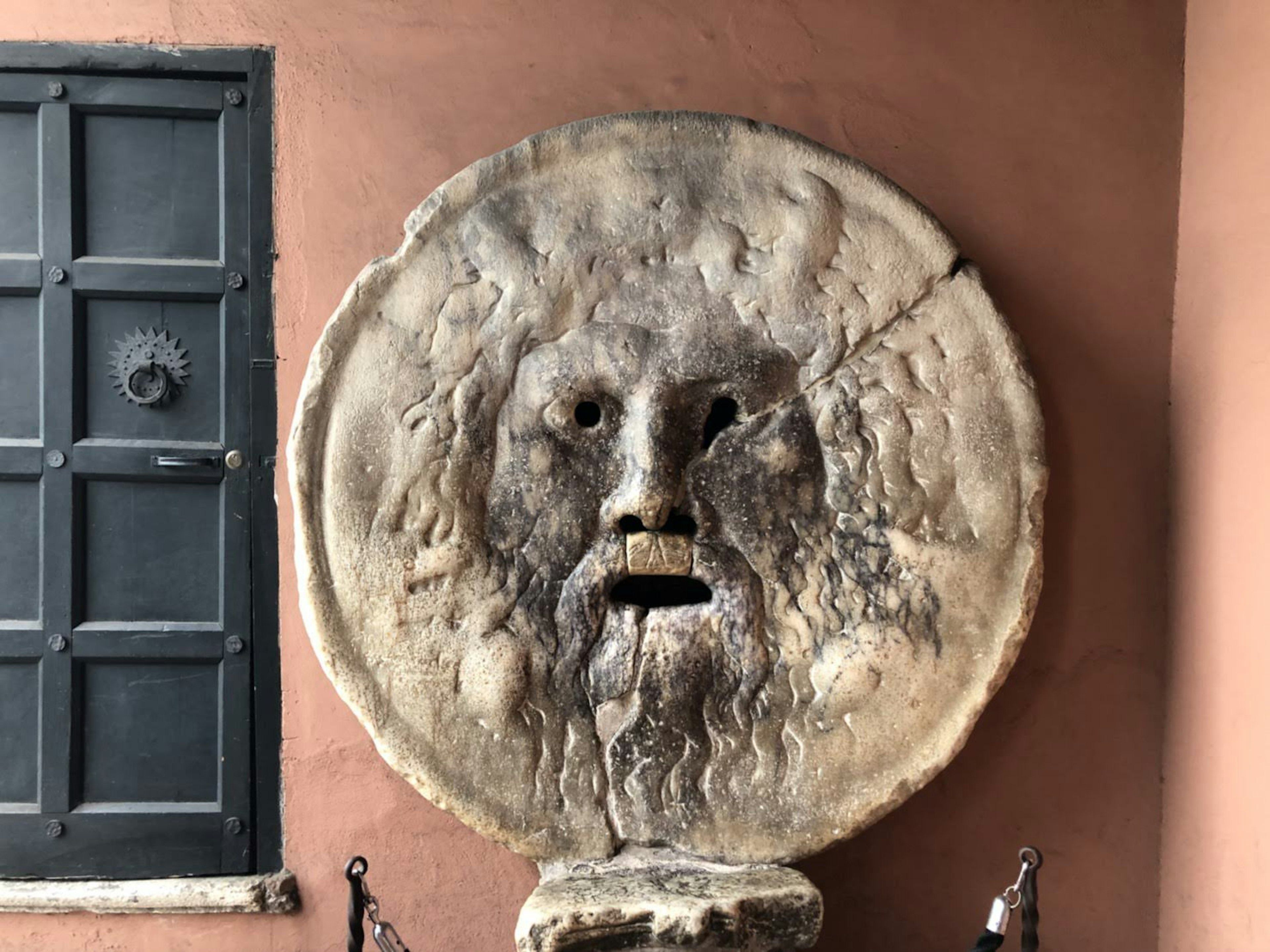 Sculpture de visage en pierre ancienne montée sur un mur