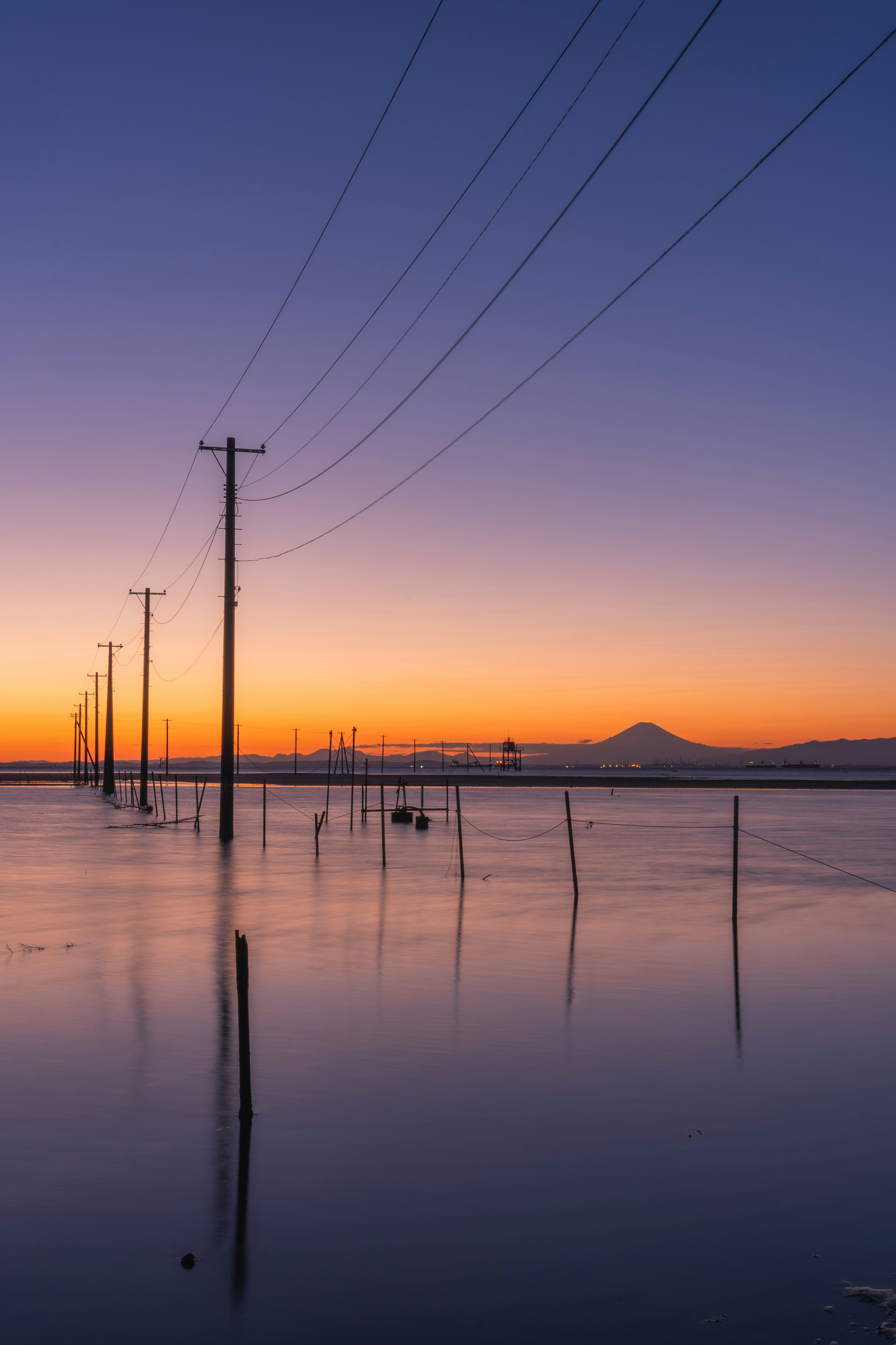 美しい夕暮れの風景に映る電柱と水面