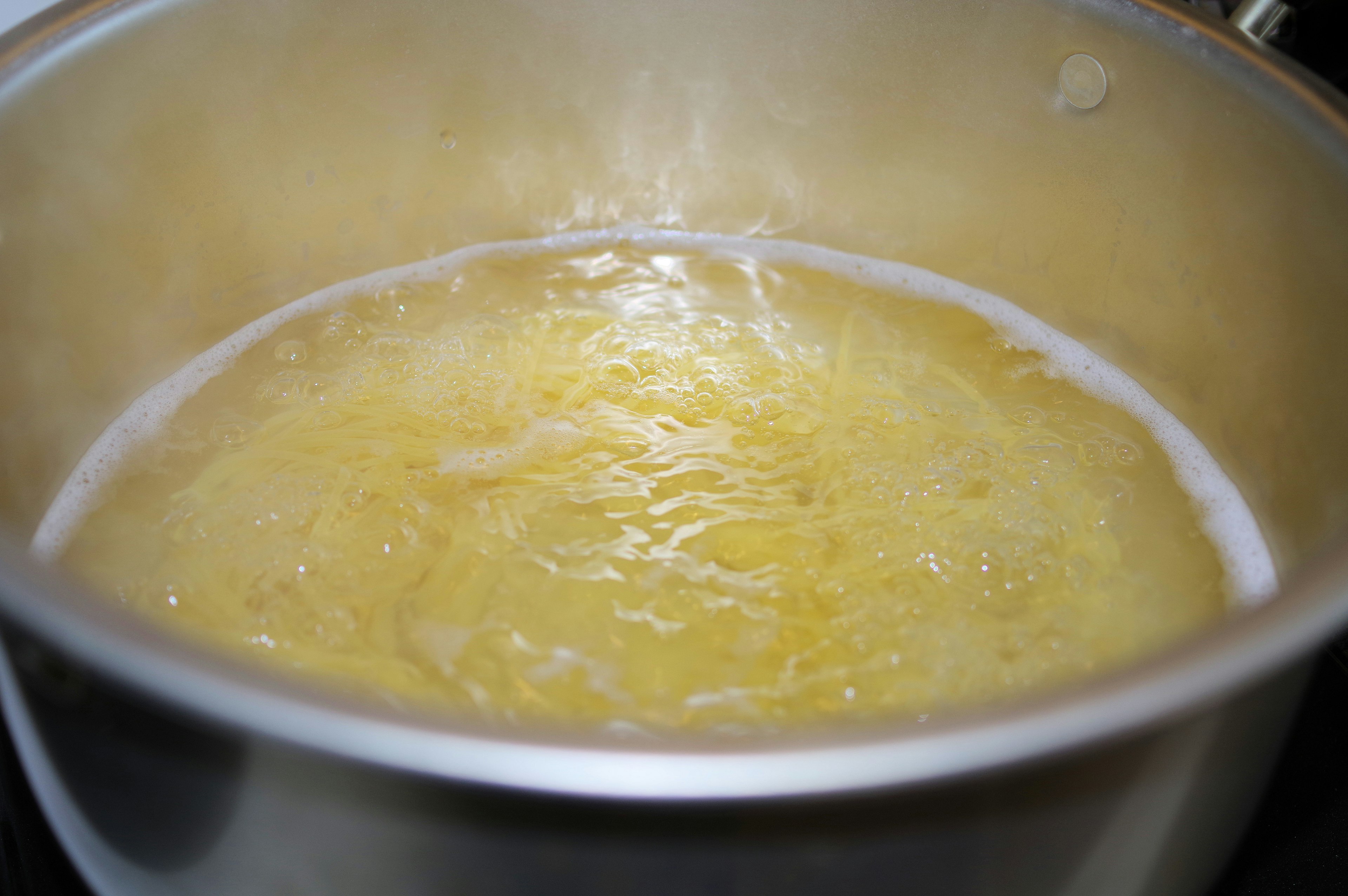 bubbling water with boiled pasta in a pot