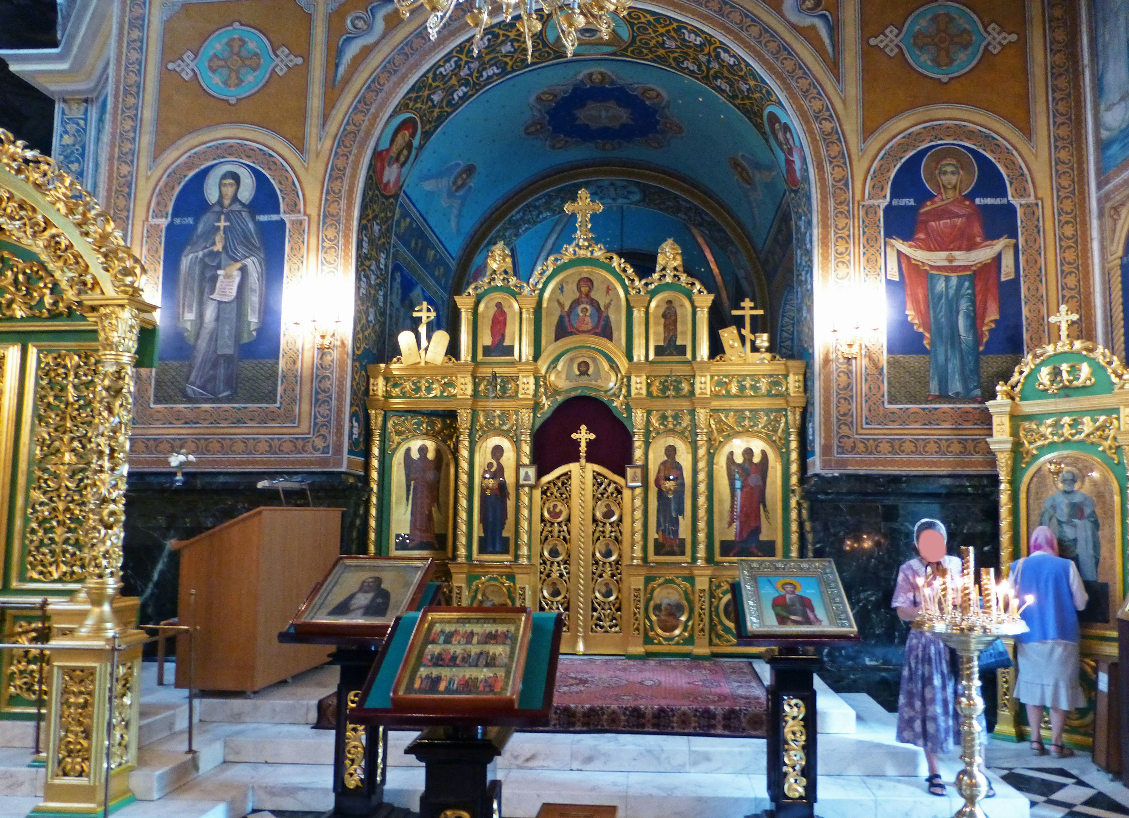 Interior of a church featuring a stunning golden altar and painted murals