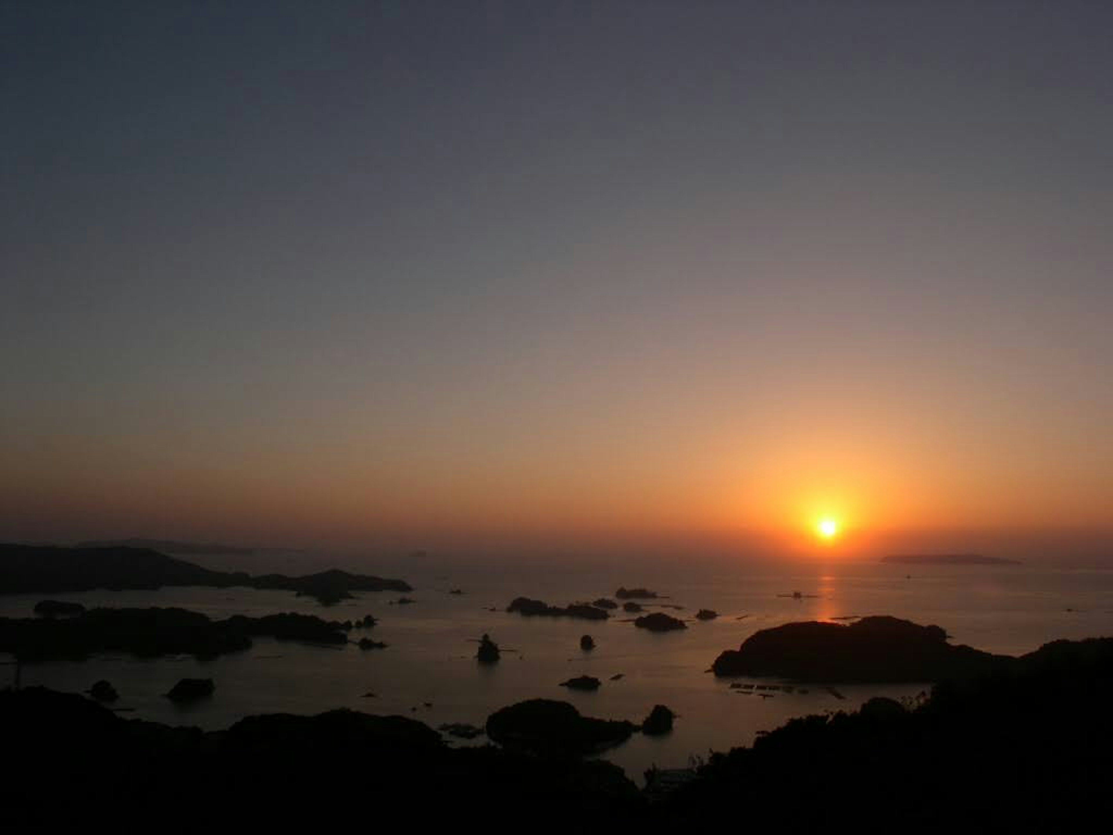 Atardecer sobre el océano con rocas visibles