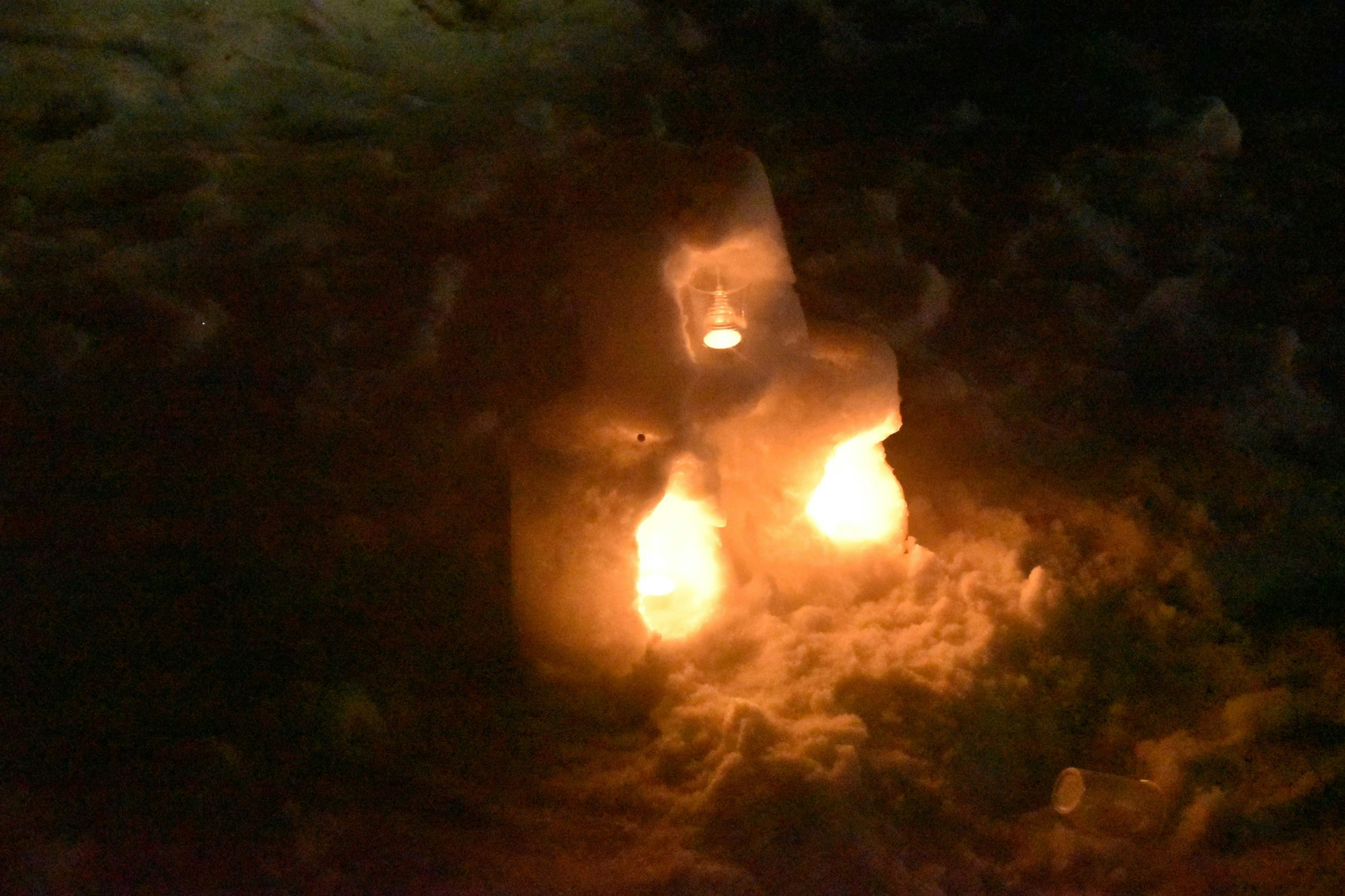 Dos velas brillantes y bloques de hielo en la oscuridad