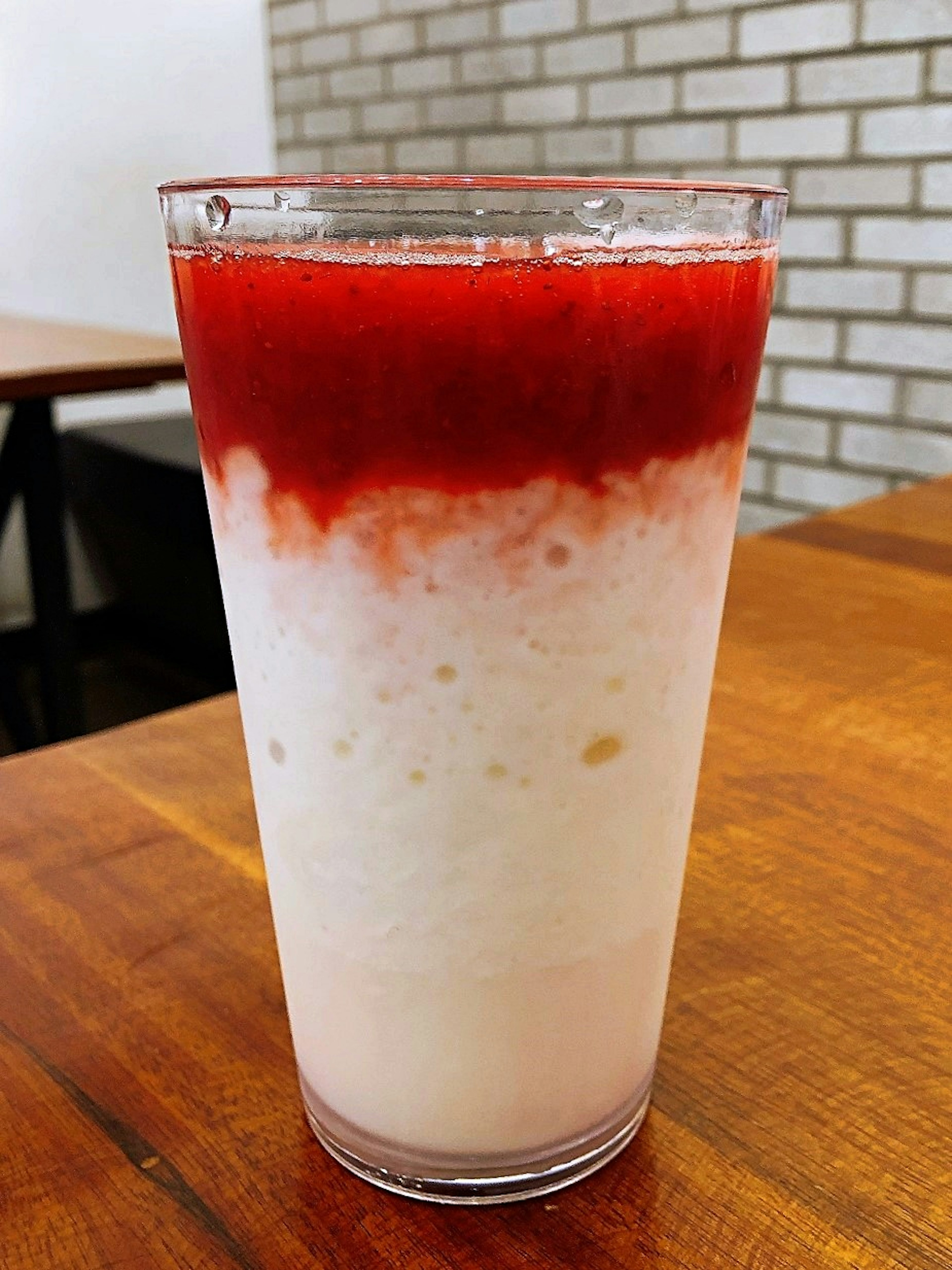 Vaso de bebida cremosa con salsa roja en la parte superior