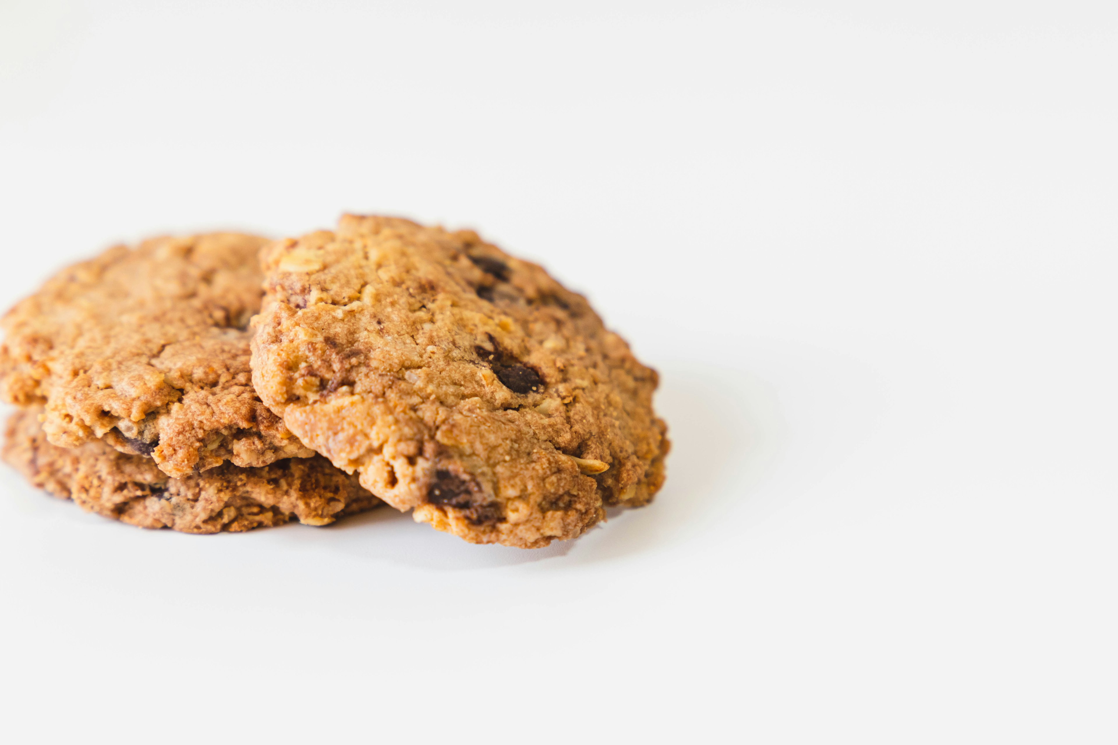 Two oatmeal cookies placed on a white background