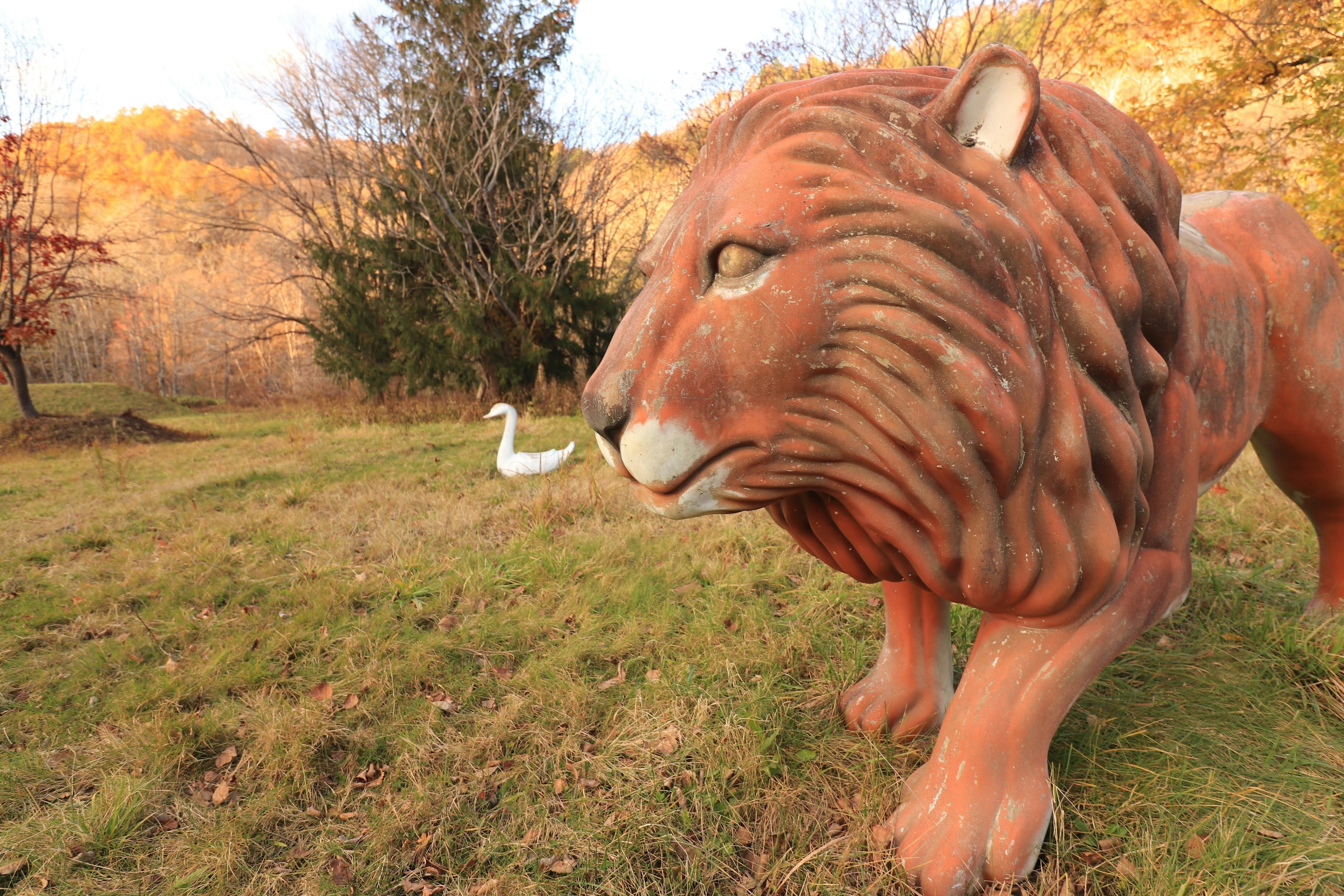 Gran escultura de león con un ave blanca cerca