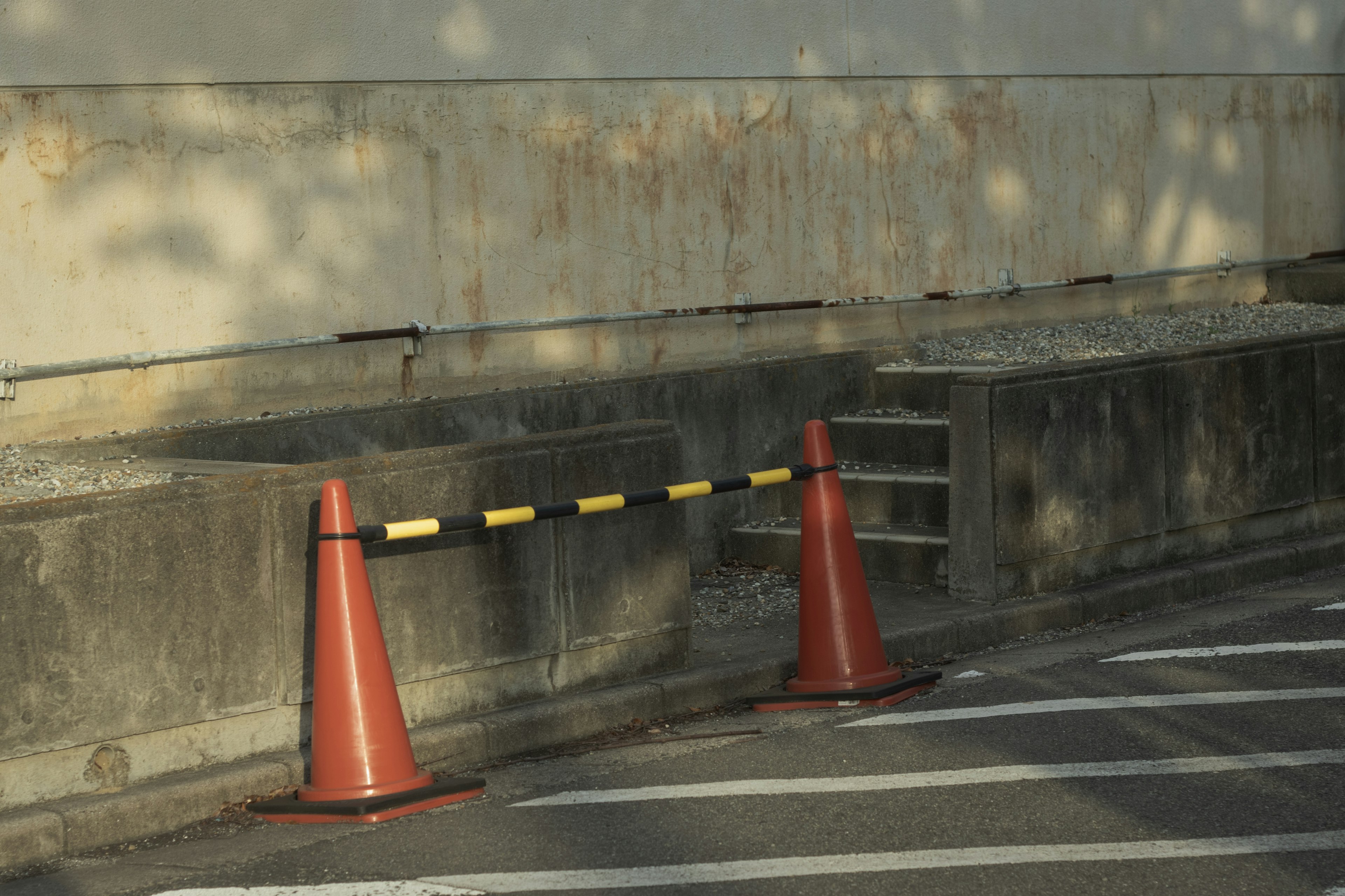 Coni stradali rossi con una barriera nera e gialla su una strada