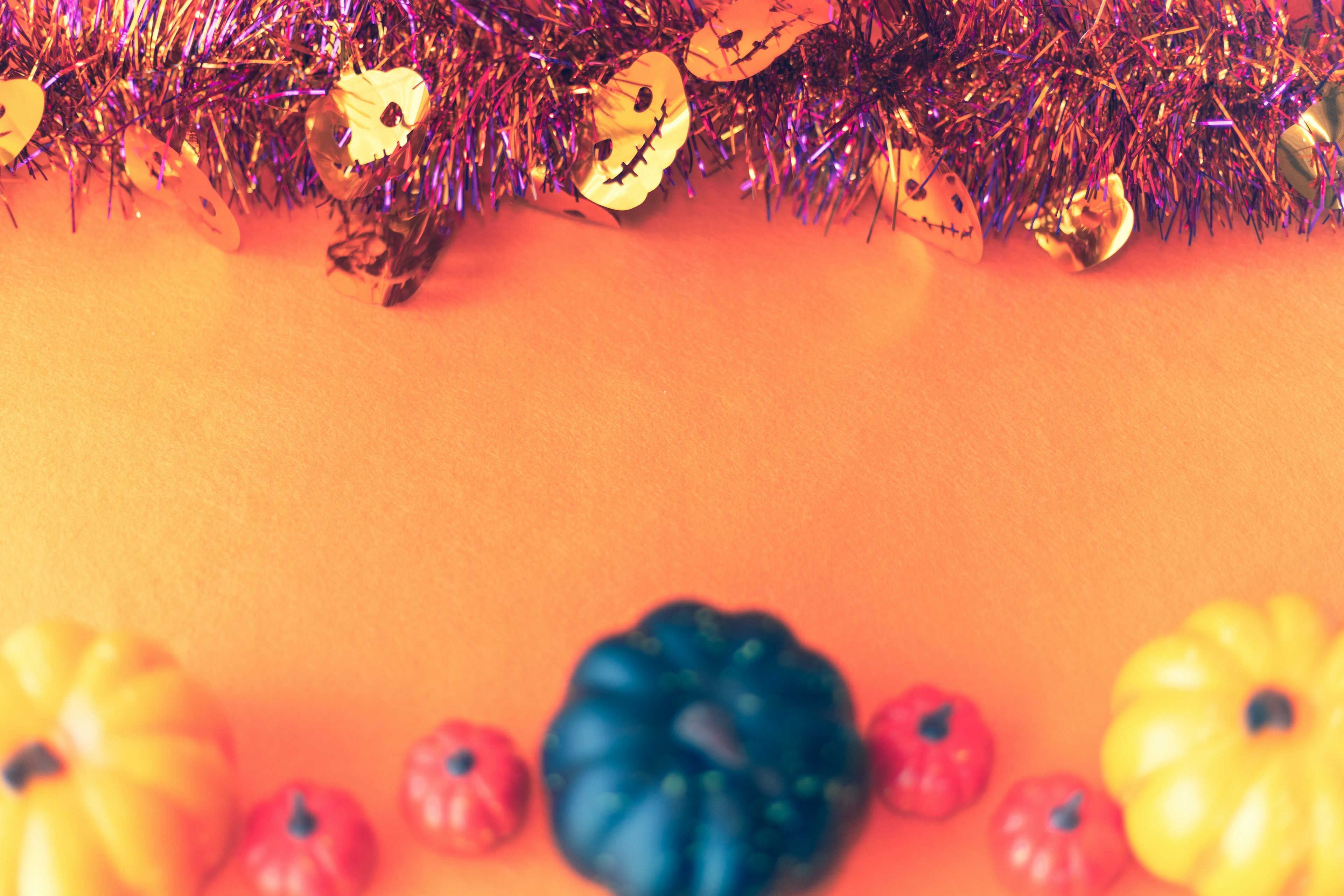 Colorful pumpkins and Halloween decorations on an orange background