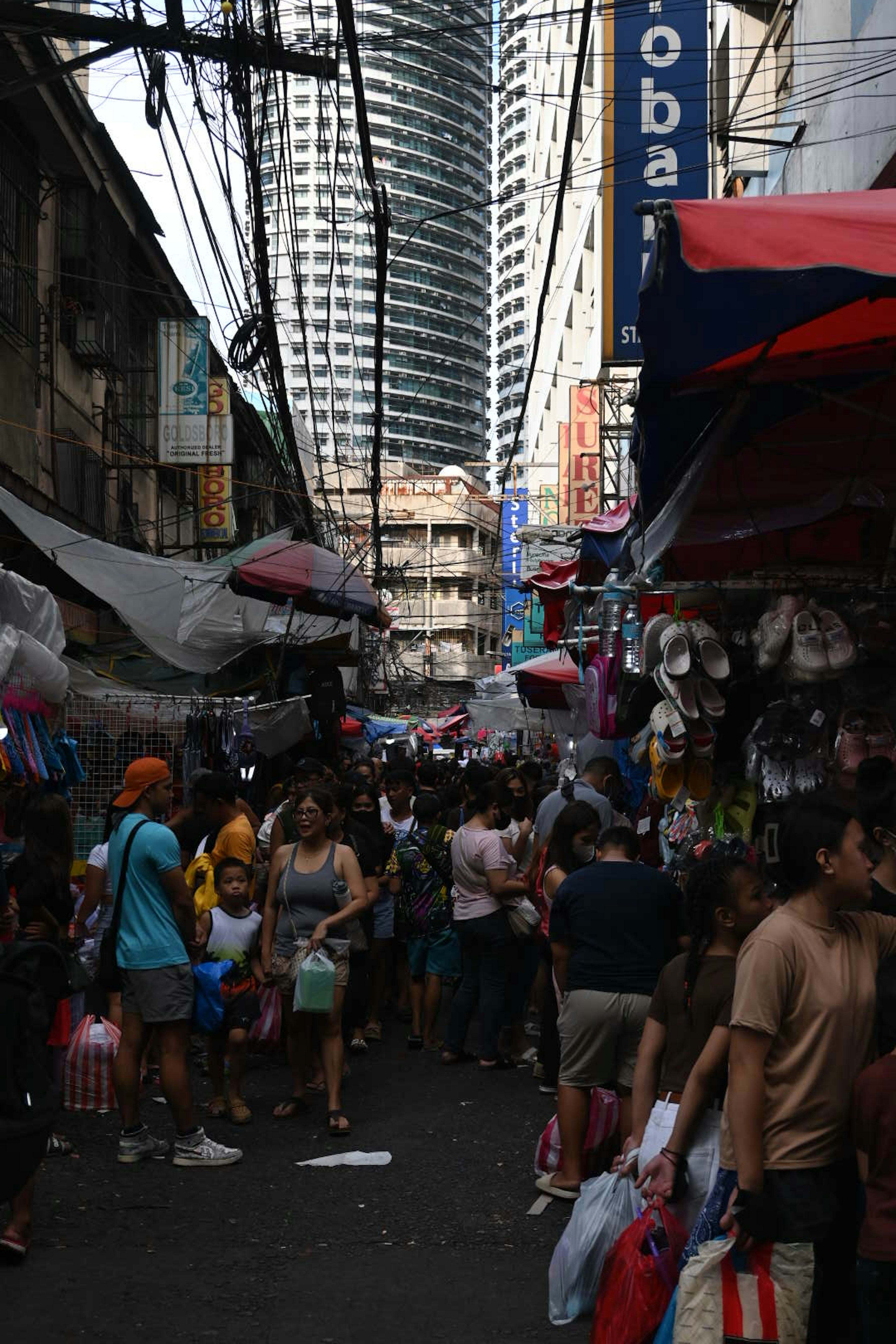 Foule de personnes dans un marché animé avec des gratte-ciels en arrière-plan