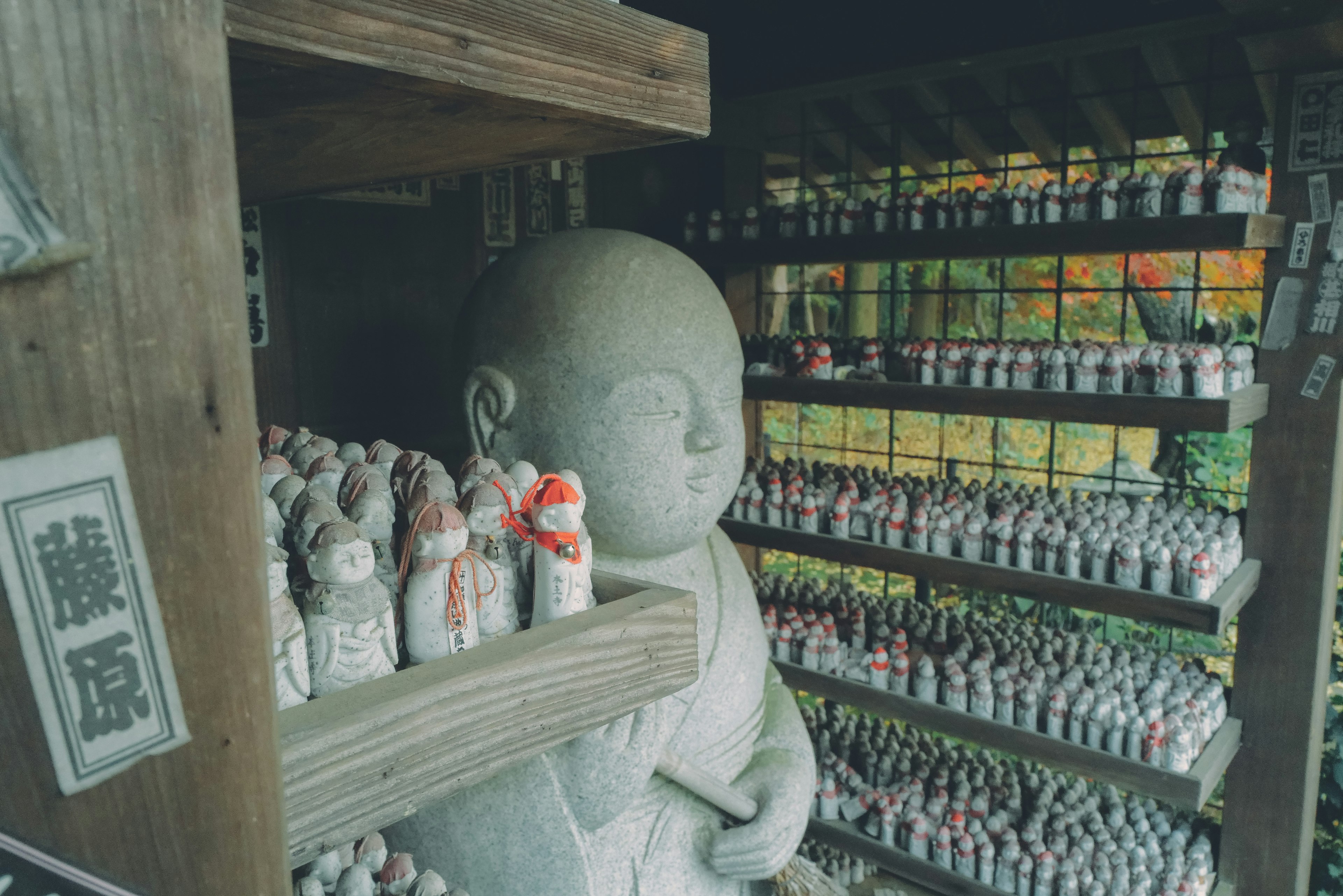 Intérieur d'un sanctuaire avec une statue en pierre et des figurines sur des étagères