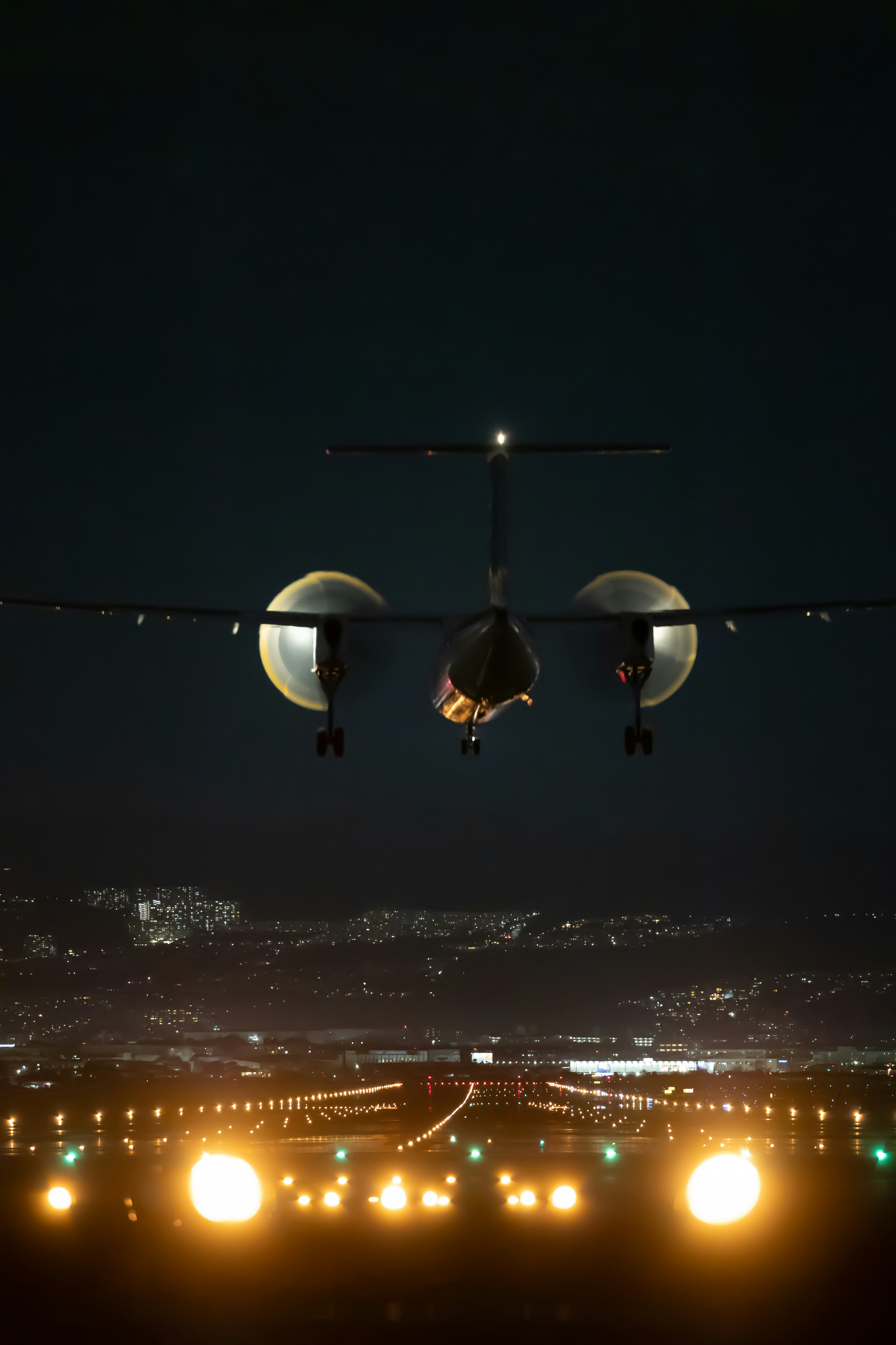 Airplane landing at night with illuminated runway lights