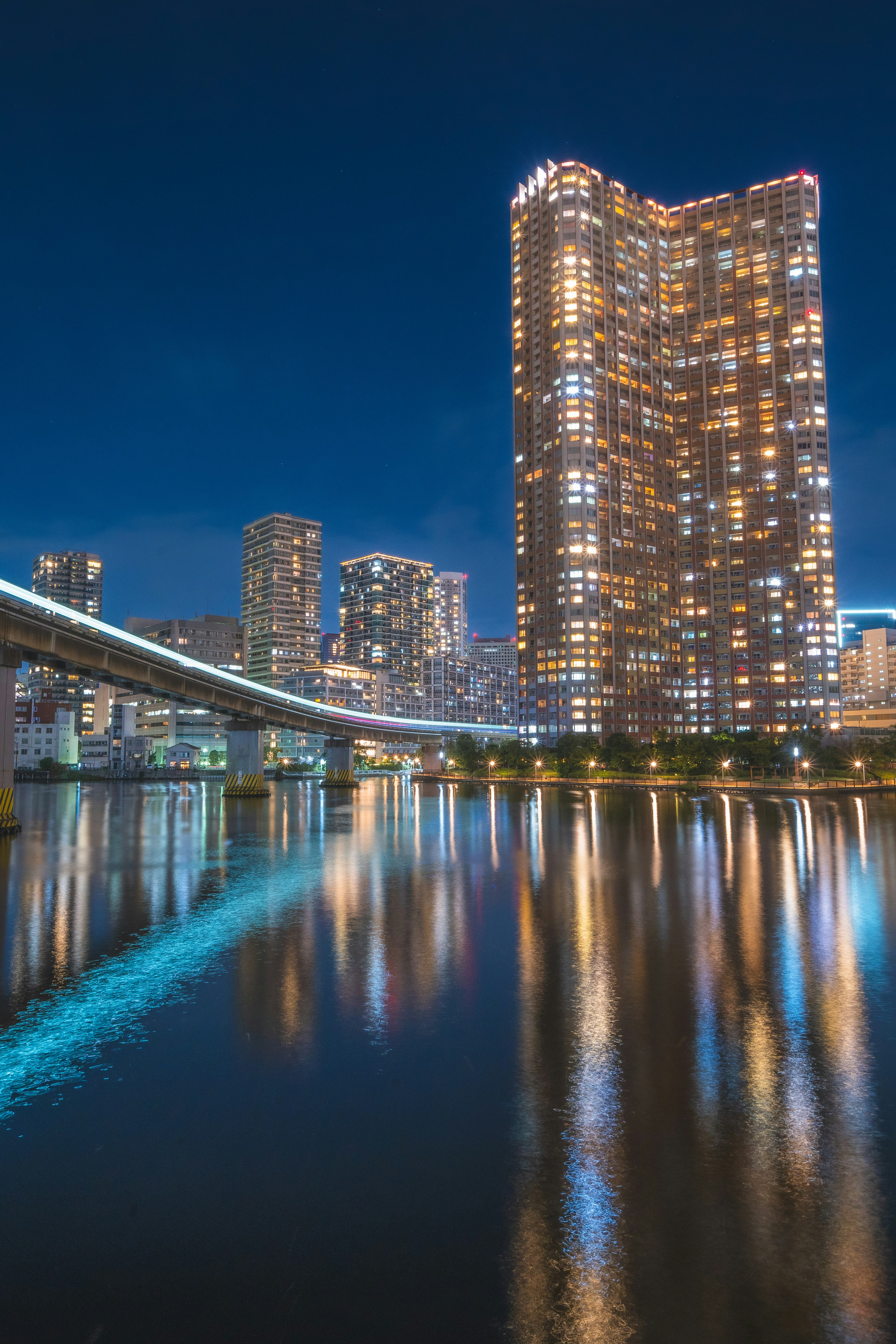 夜の都市景観と川の反射を持つ高層ビル群