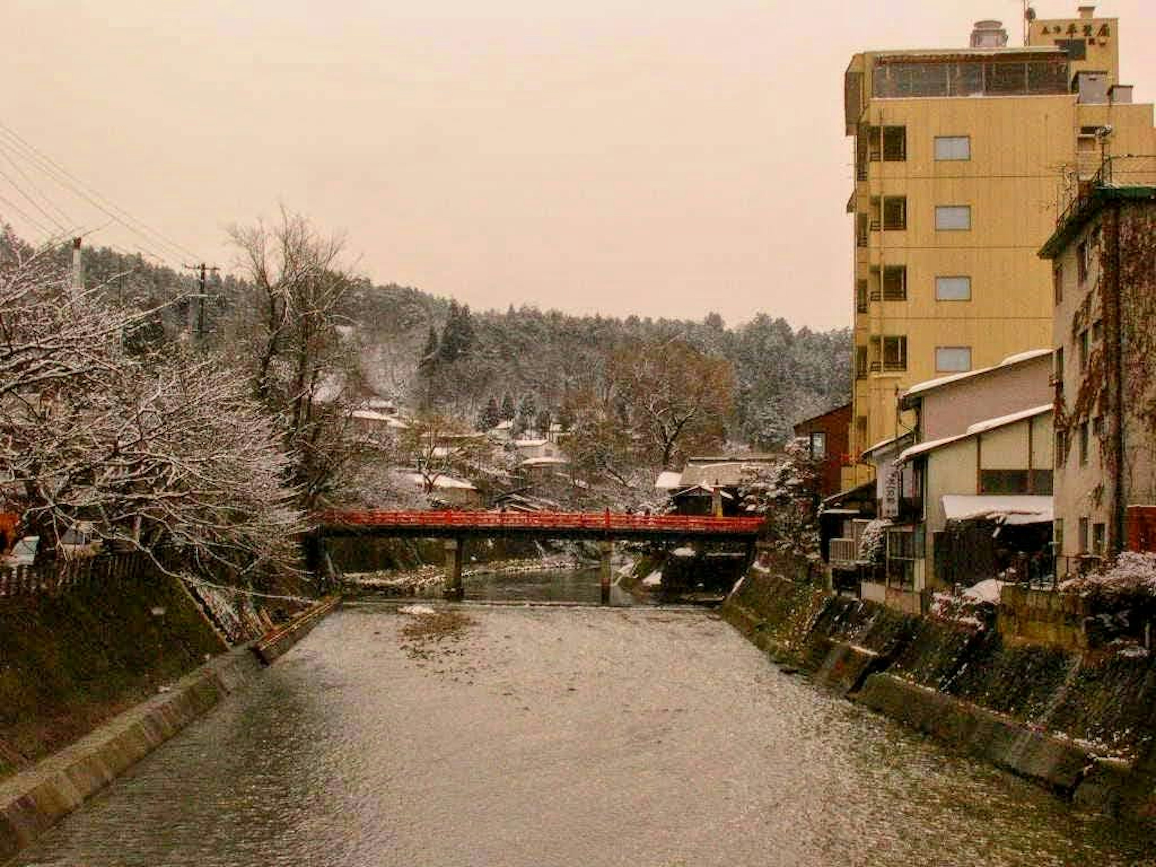 Escena de río y puente cubiertos de nieve