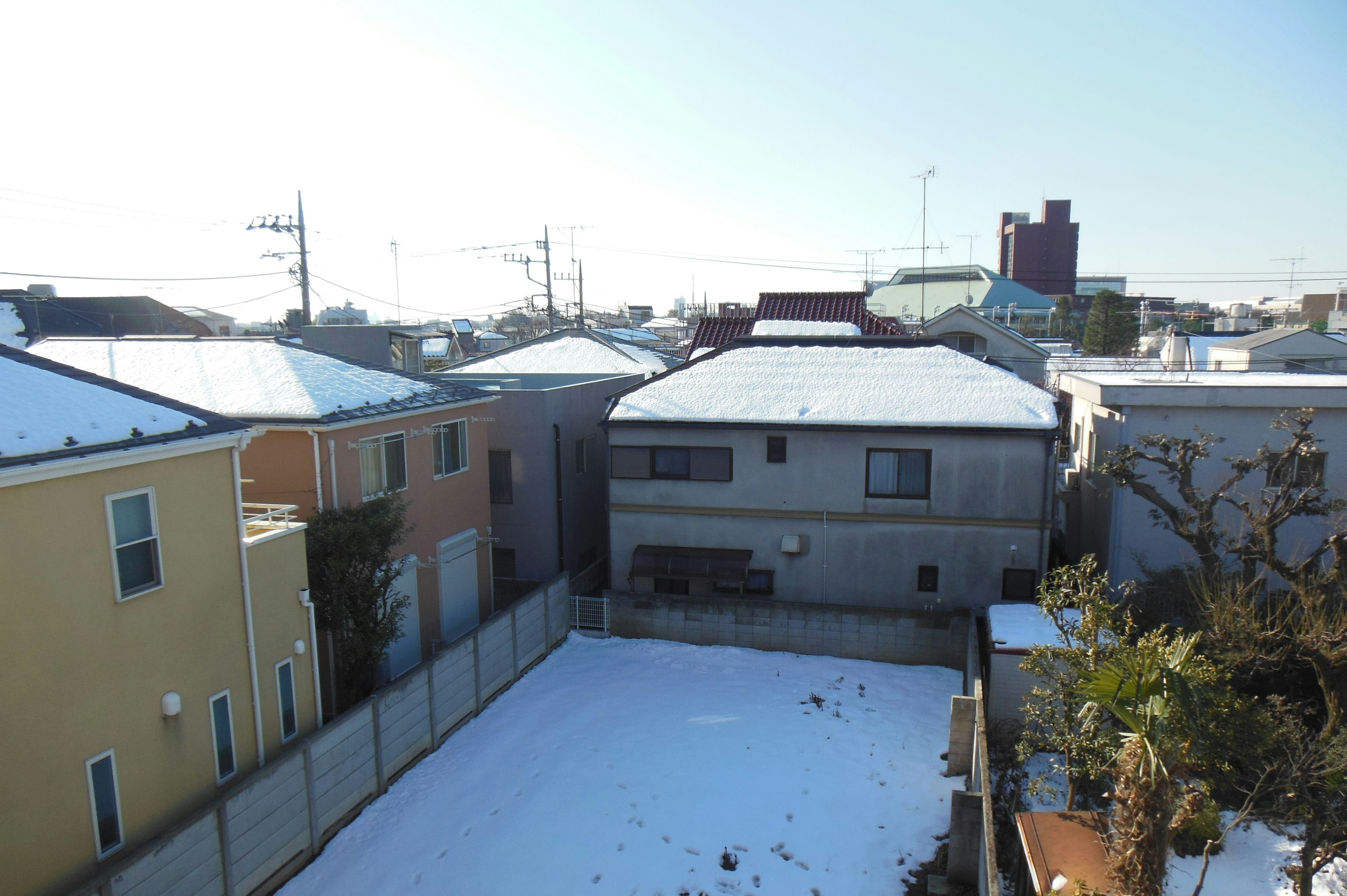 Snow-covered residential area with houses and clear sky