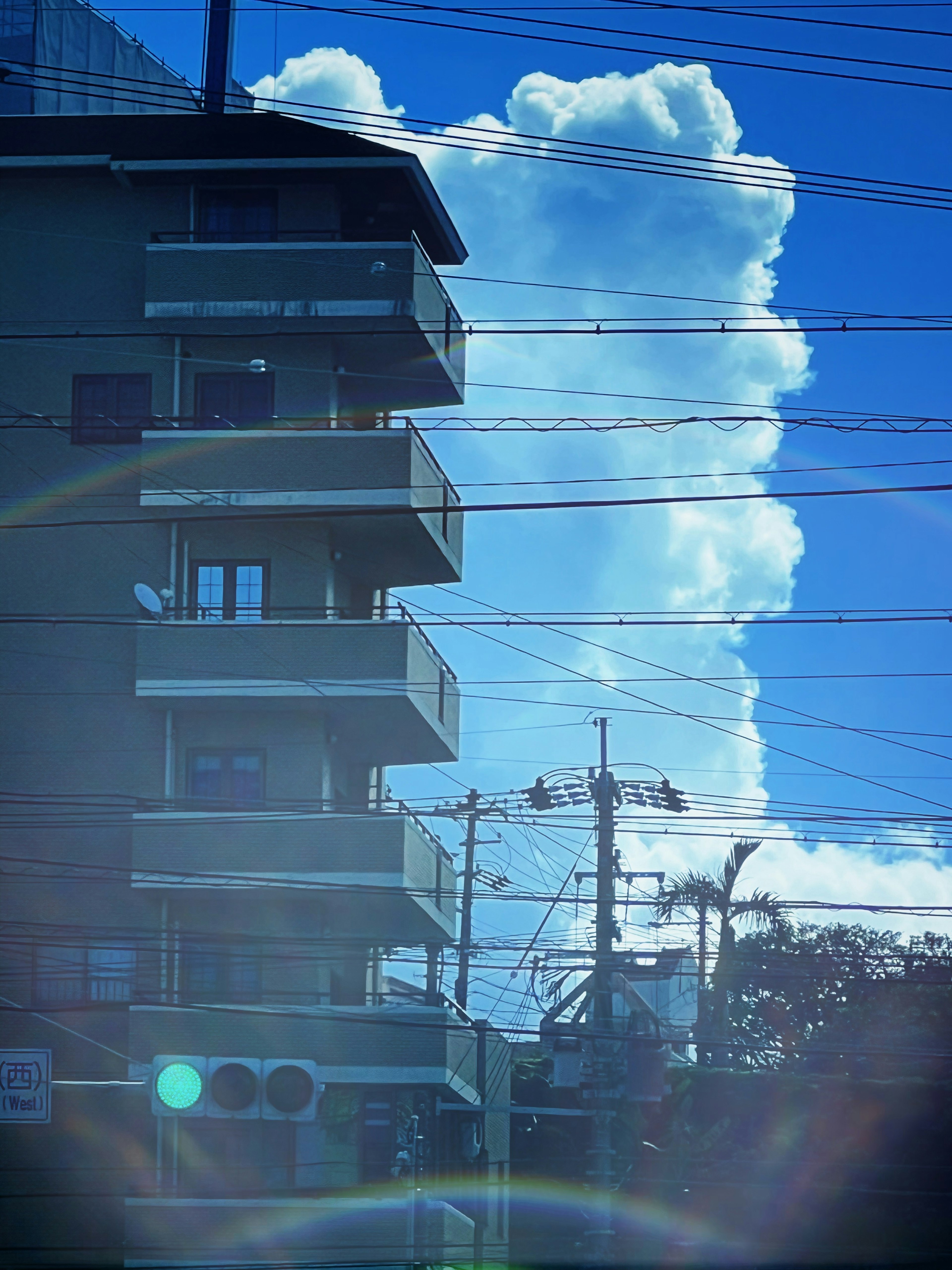 Silueta de un edificio contra un cielo azul brillante con grandes nubes blancas