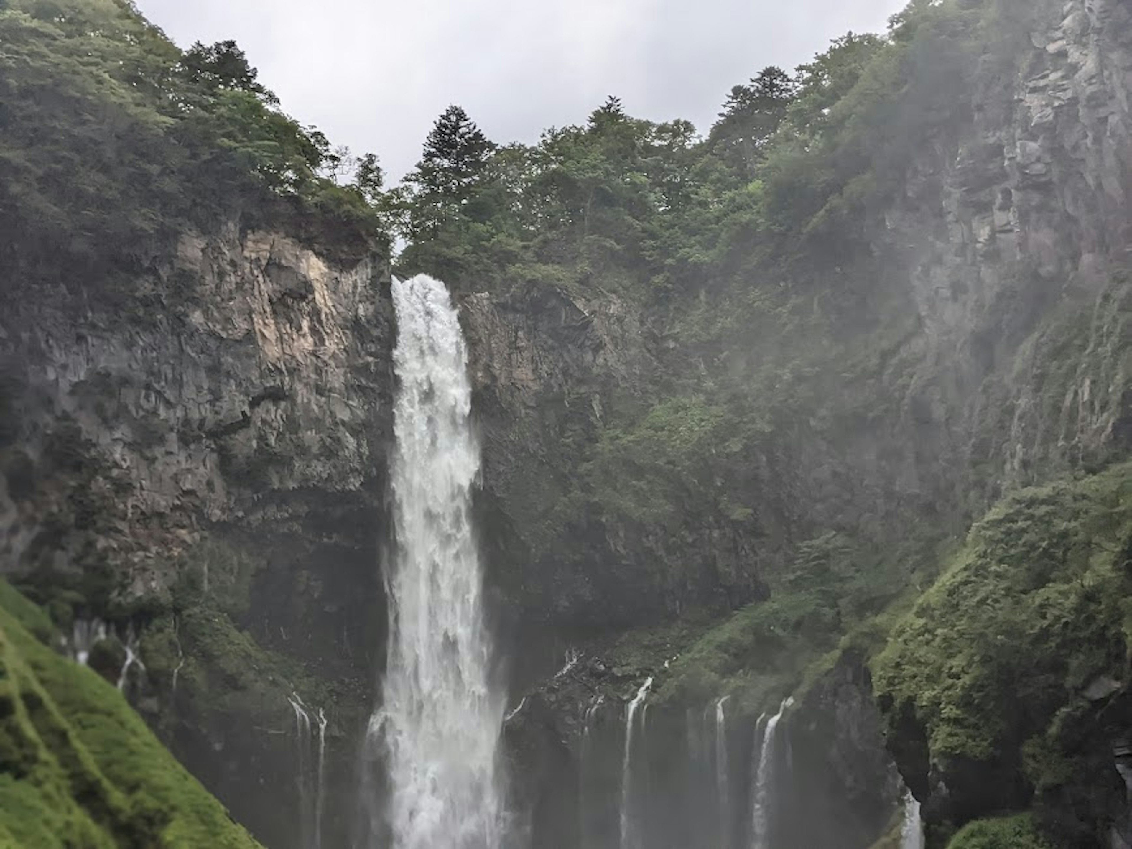 Air terjun megah mengalir melalui pegunungan lingkungan hijau subur