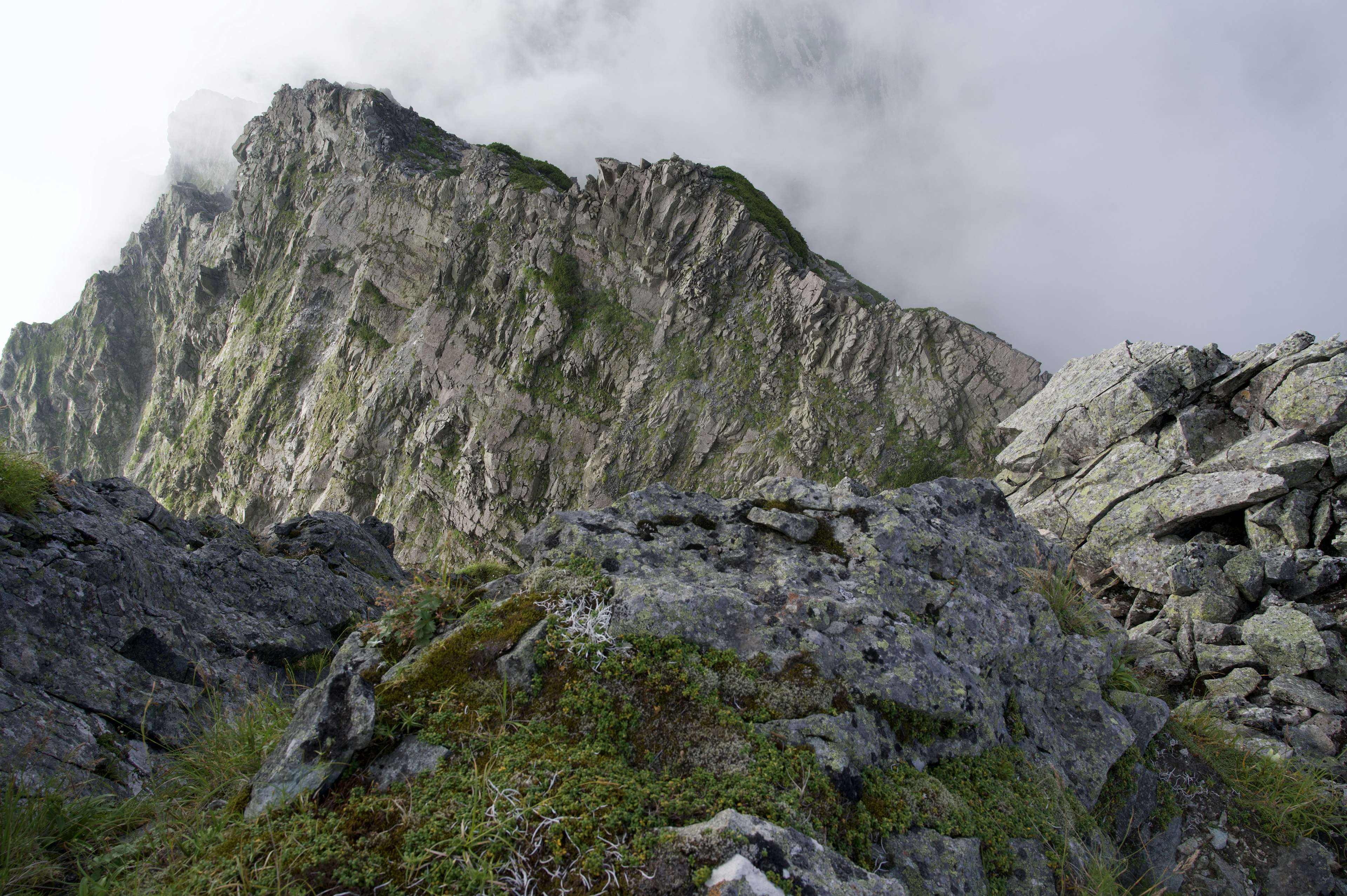 Paisaje montañoso rocoso con nubes y acantilados empinados