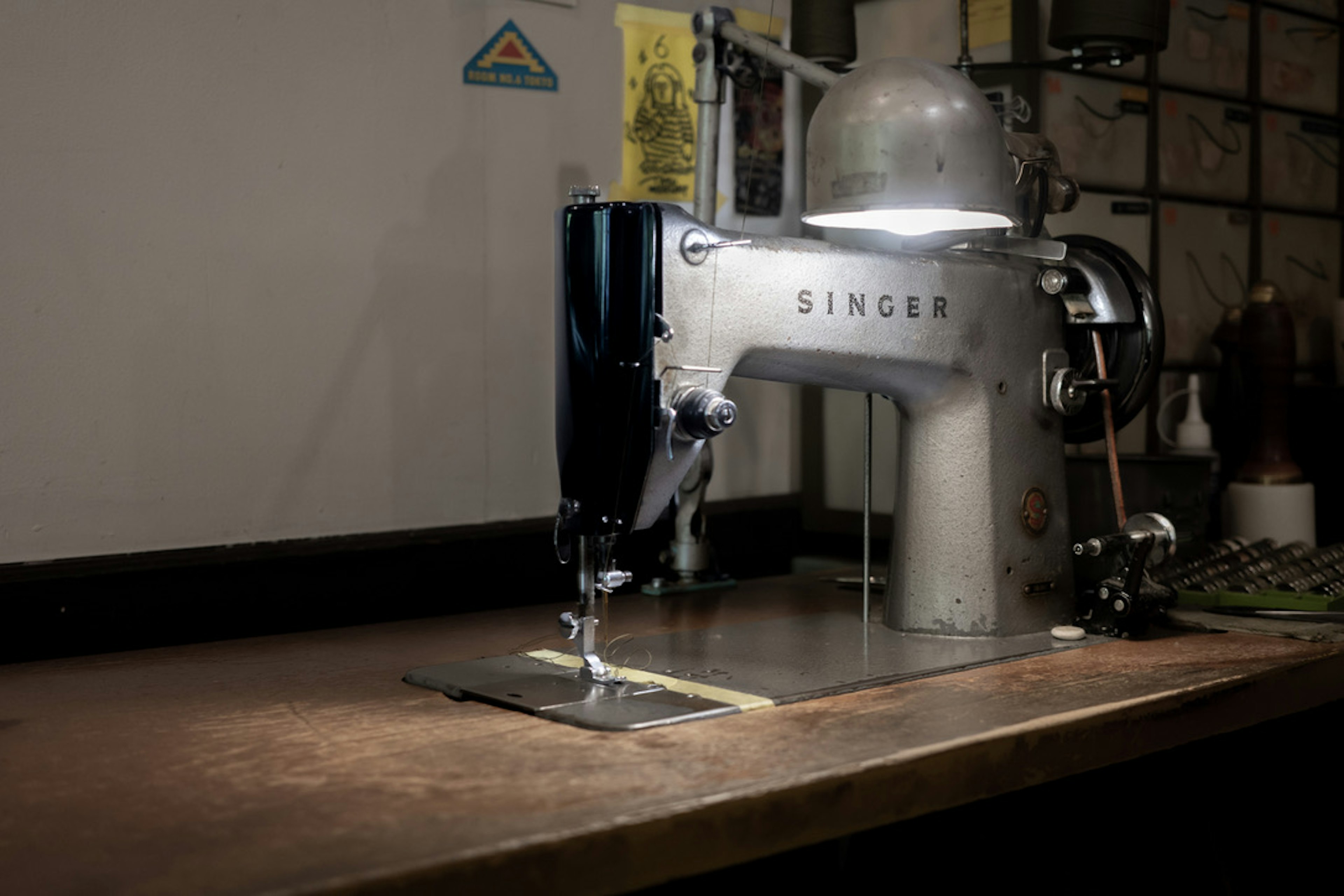 An old Singer sewing machine placed on a wooden table