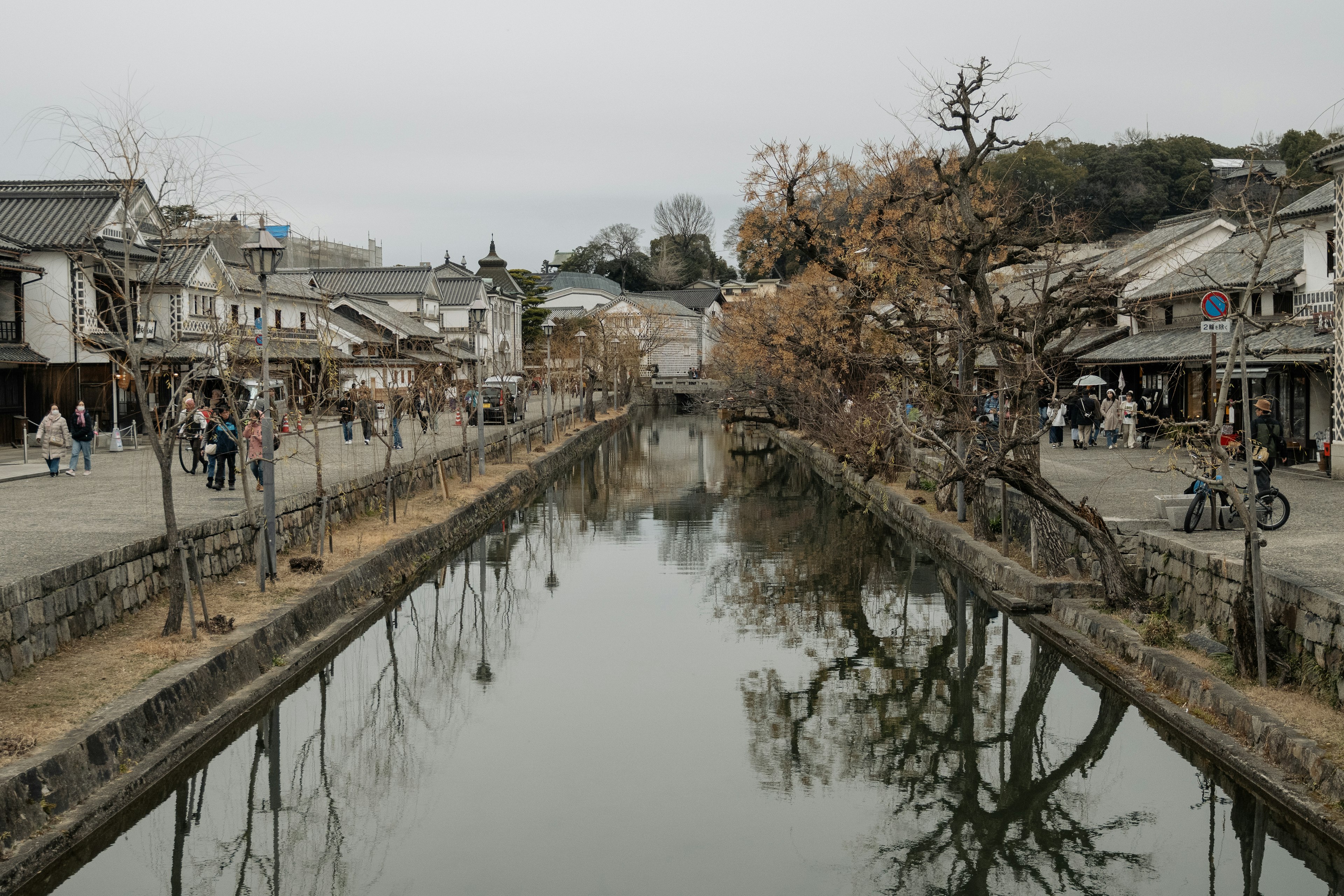 Ruhige Stadt am Fluss mit Herbstbäumen und Reflexionen