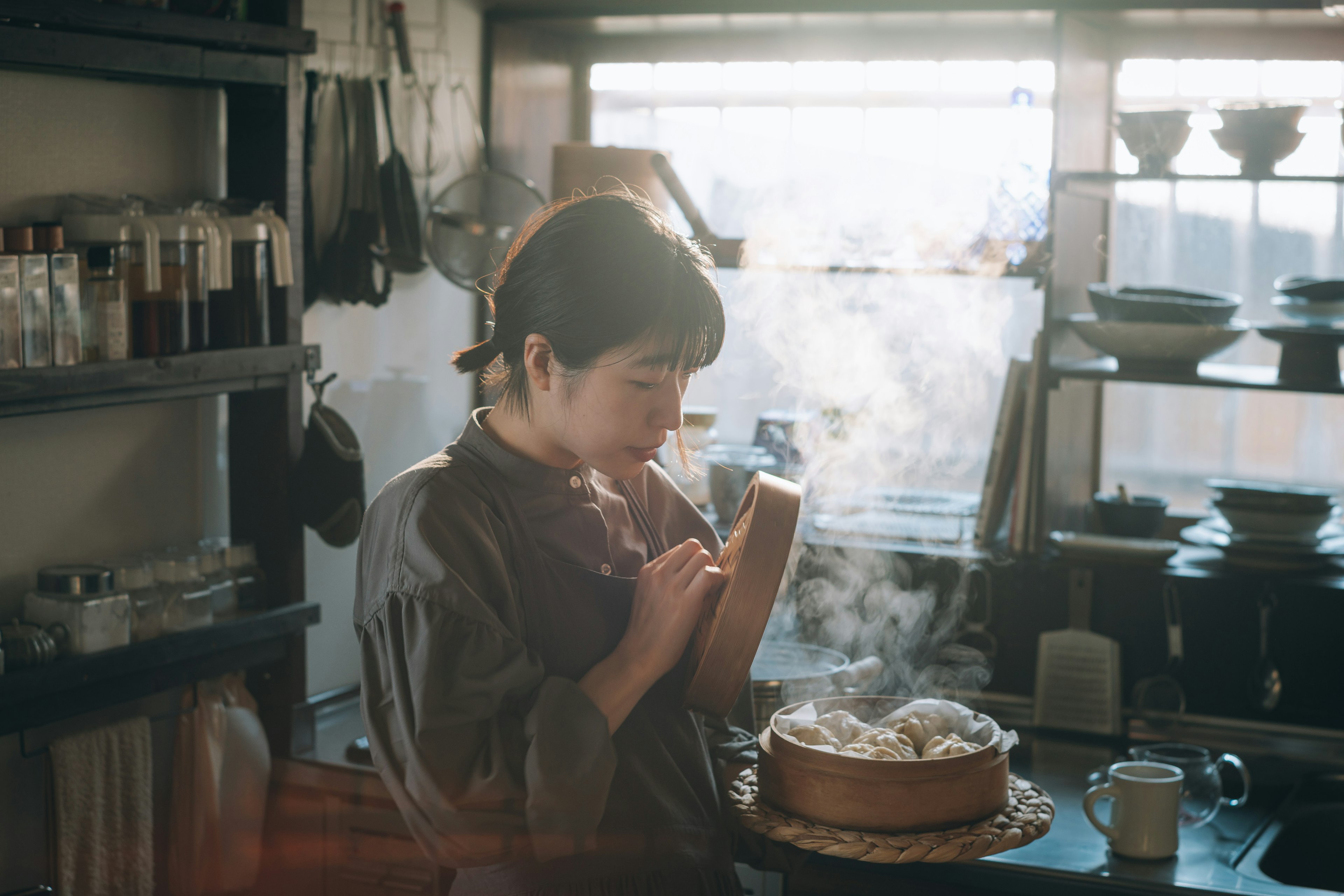 Une femme cuisinant avec un cuiseur vapeur dans une cuisine chaleureuse