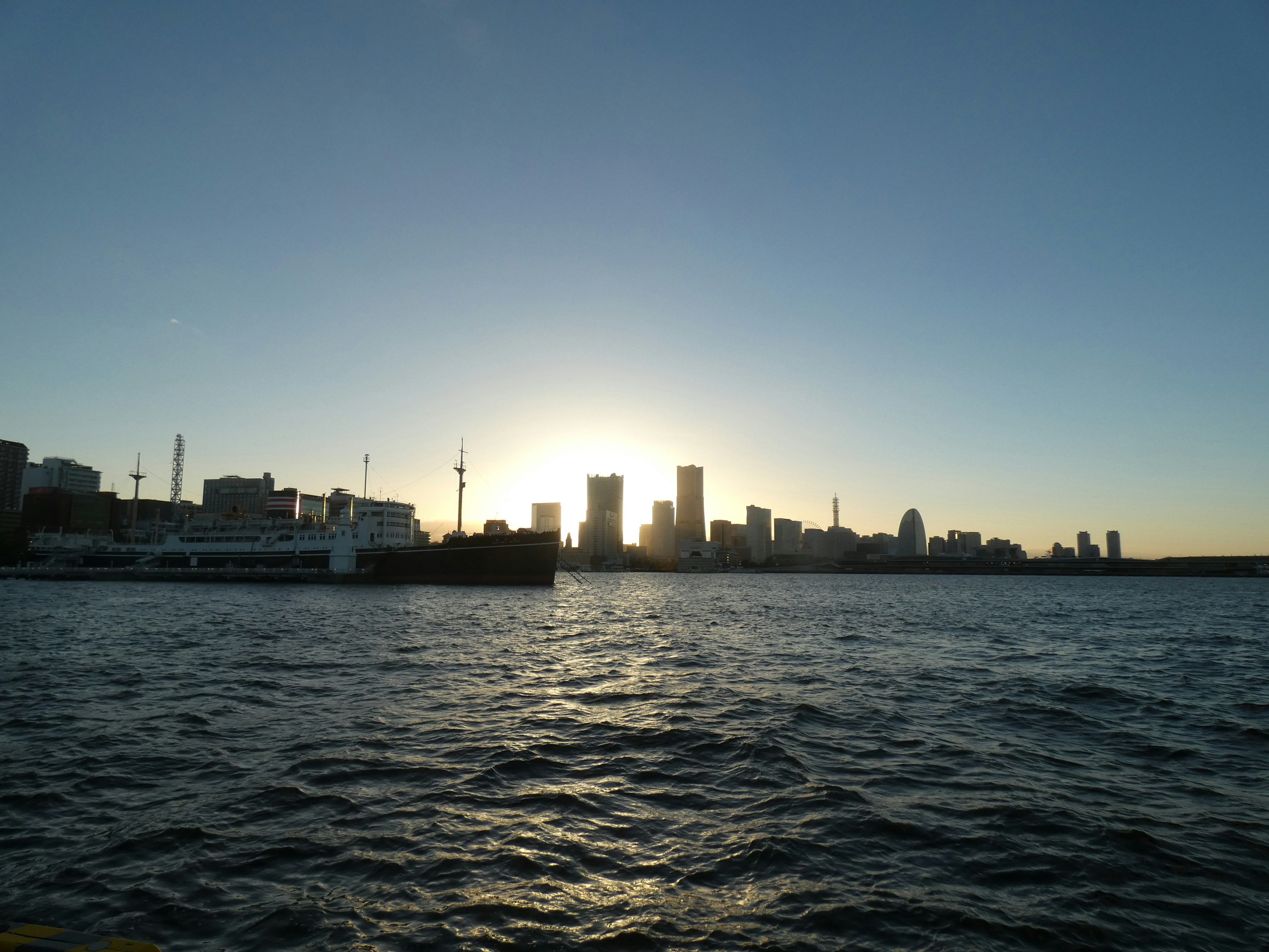 Silhouette d'une ville au coucher du soleil sur l'eau