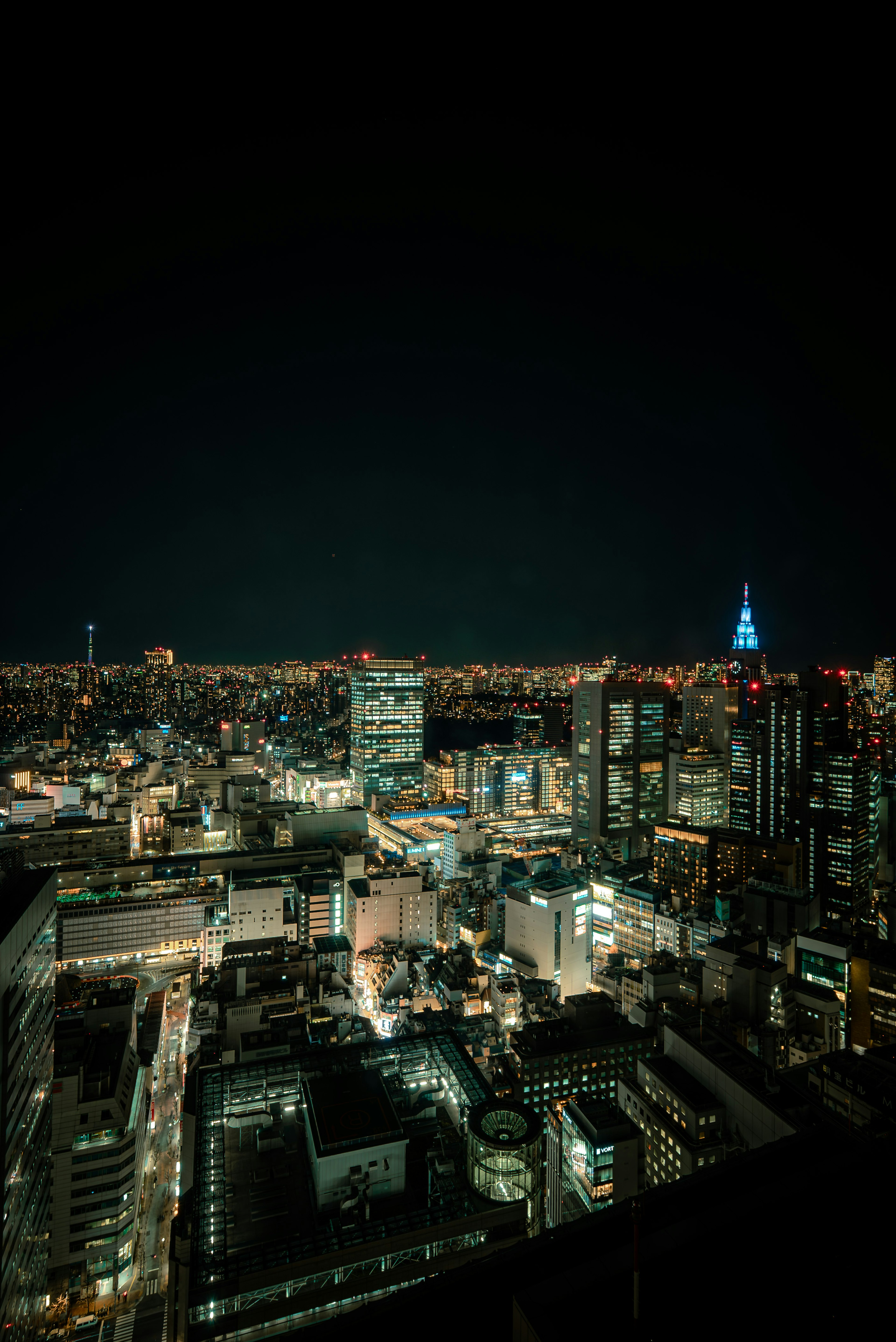 Pemandangan malam Tokyo dengan gedung pencakar langit yang diterangi dan Tokyo Tower