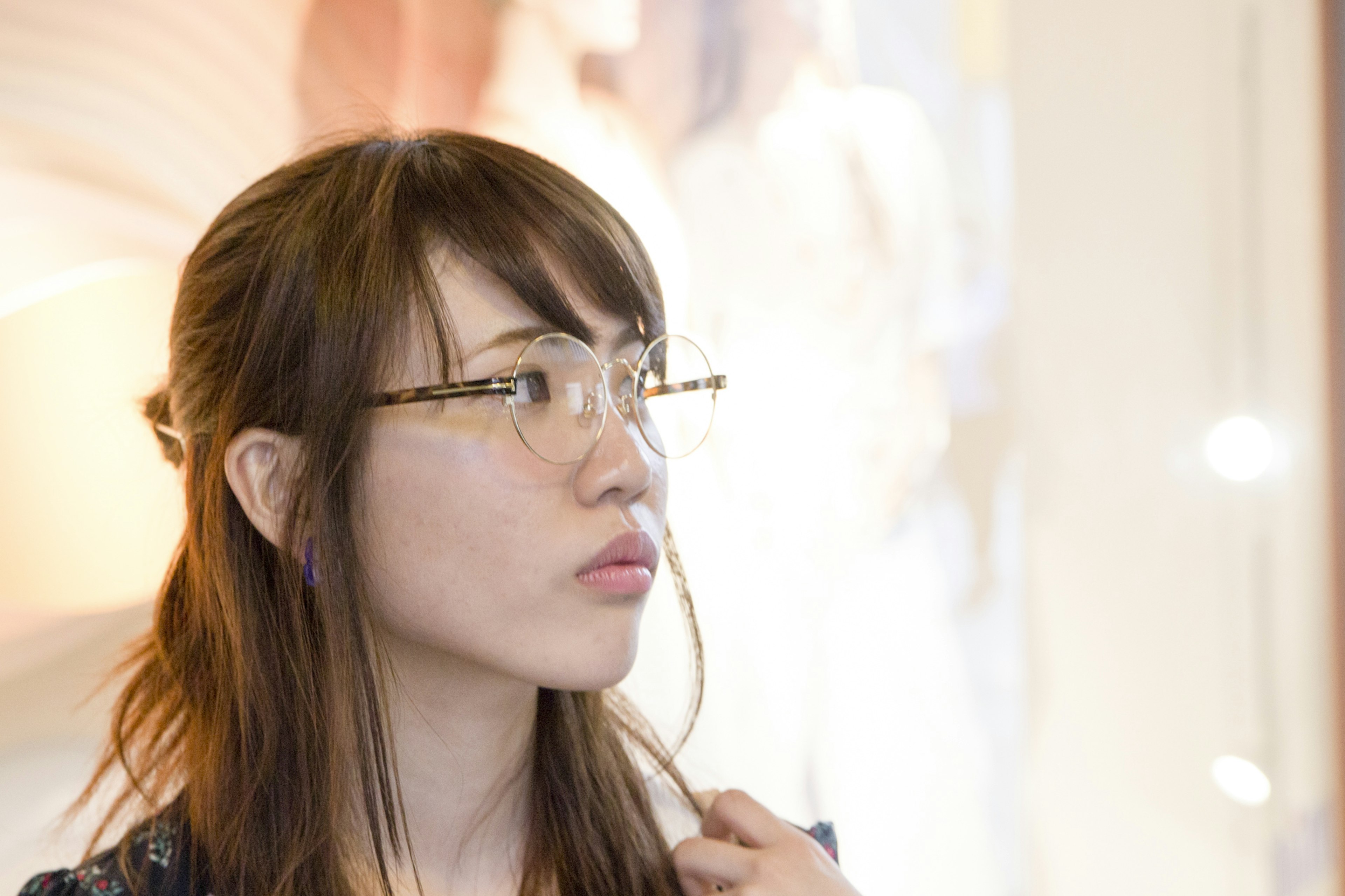 A woman wearing glasses looking contemplative