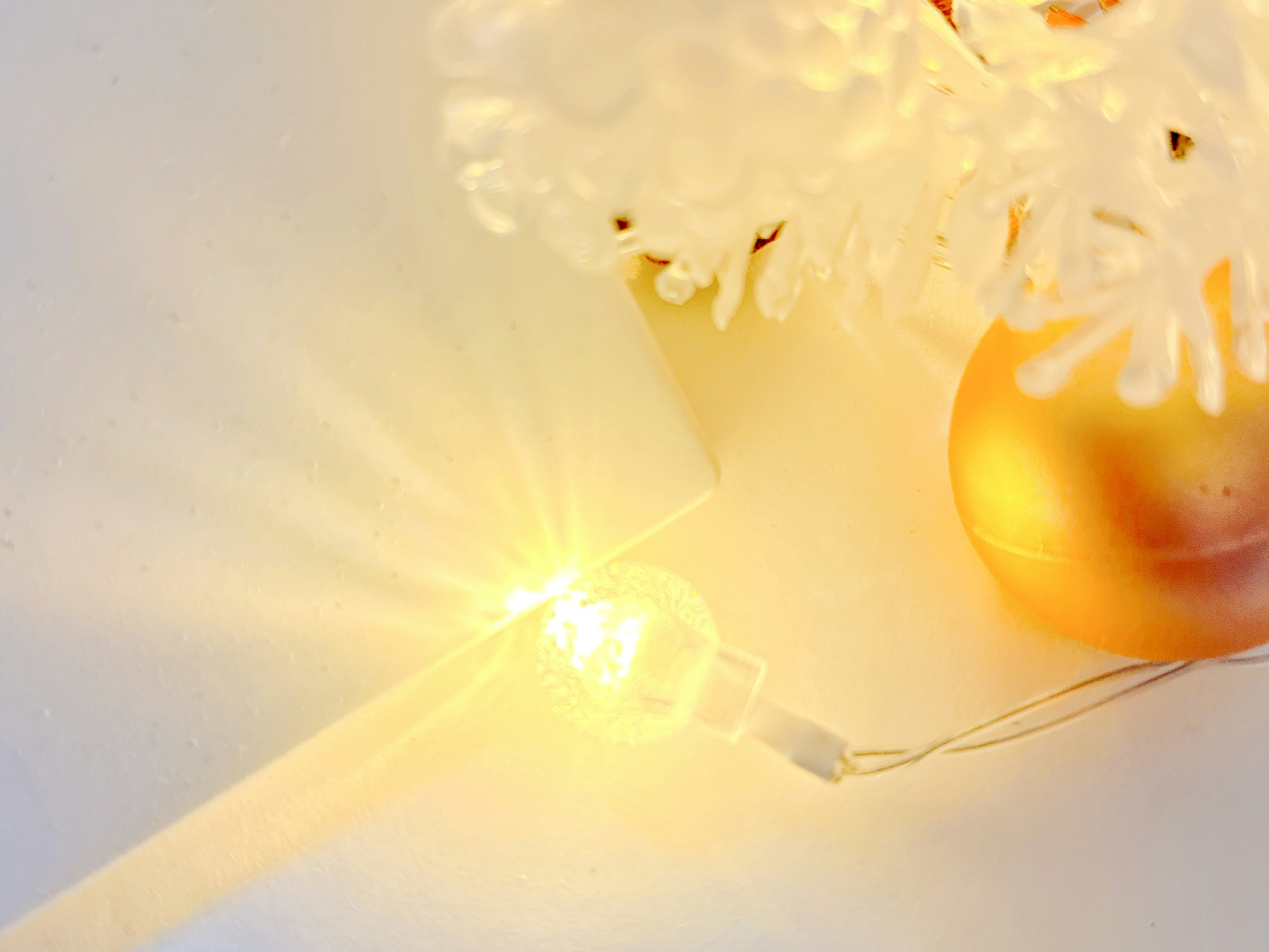 Scene featuring an orange ball and glowing LED light used as Christmas tree decorations