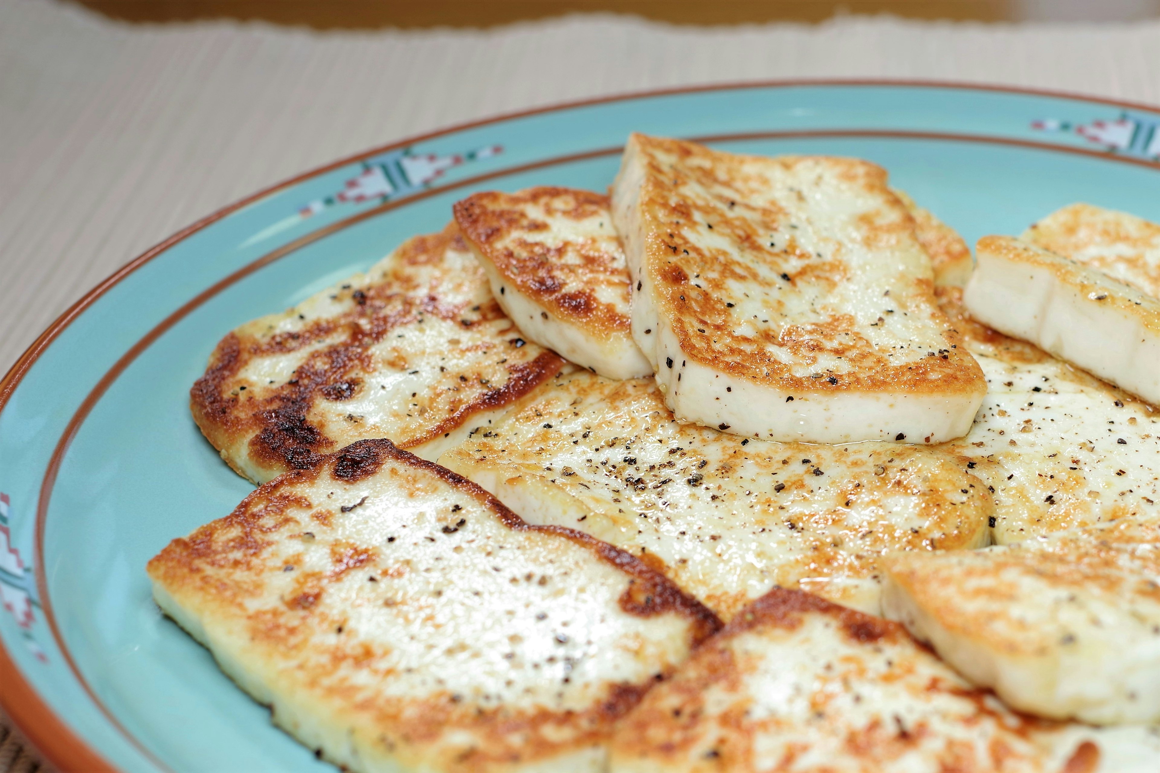 Fette di formaggio grigliato disposte su un piatto blu