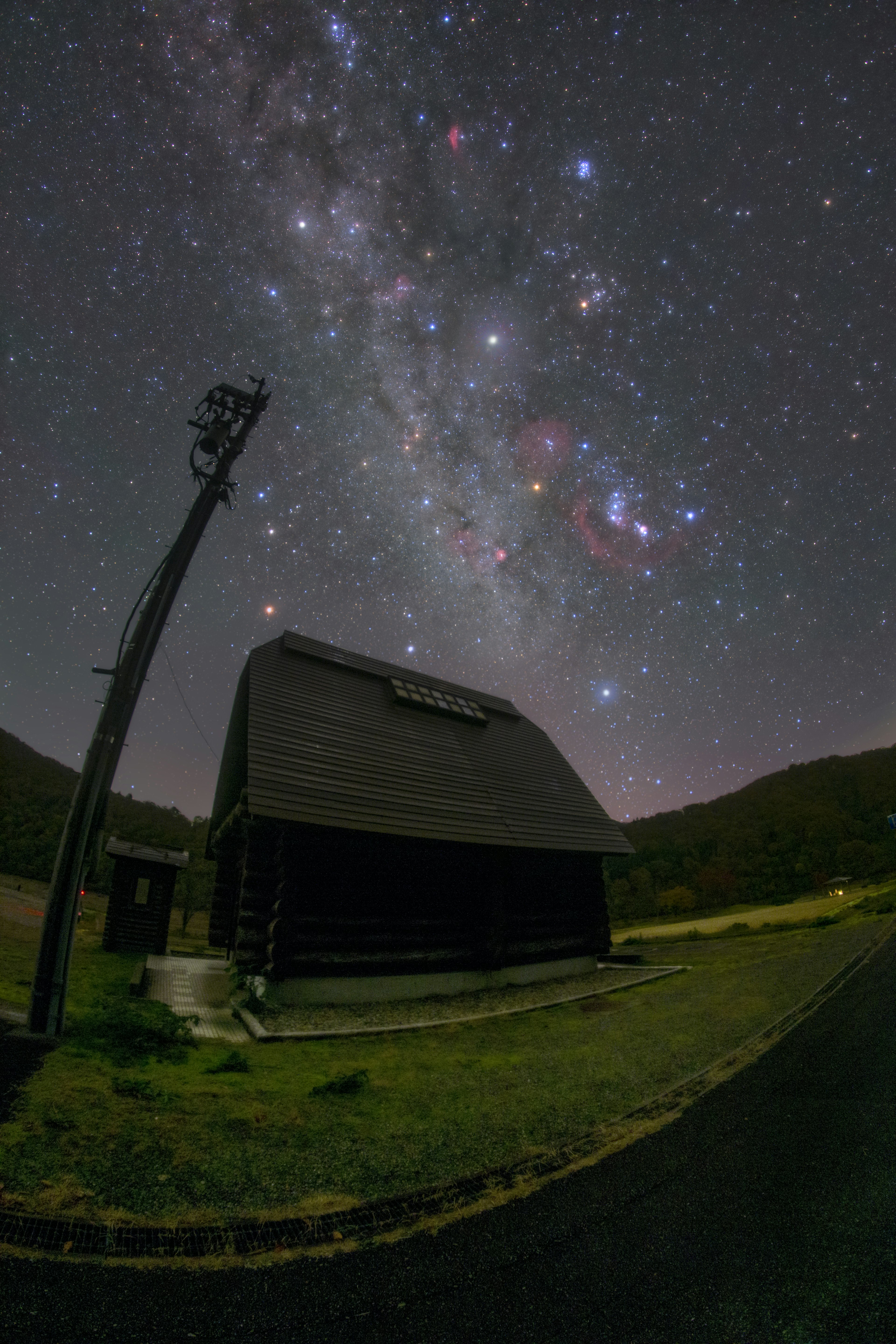 星空の下にあるログハウスと銀河の美しい風景