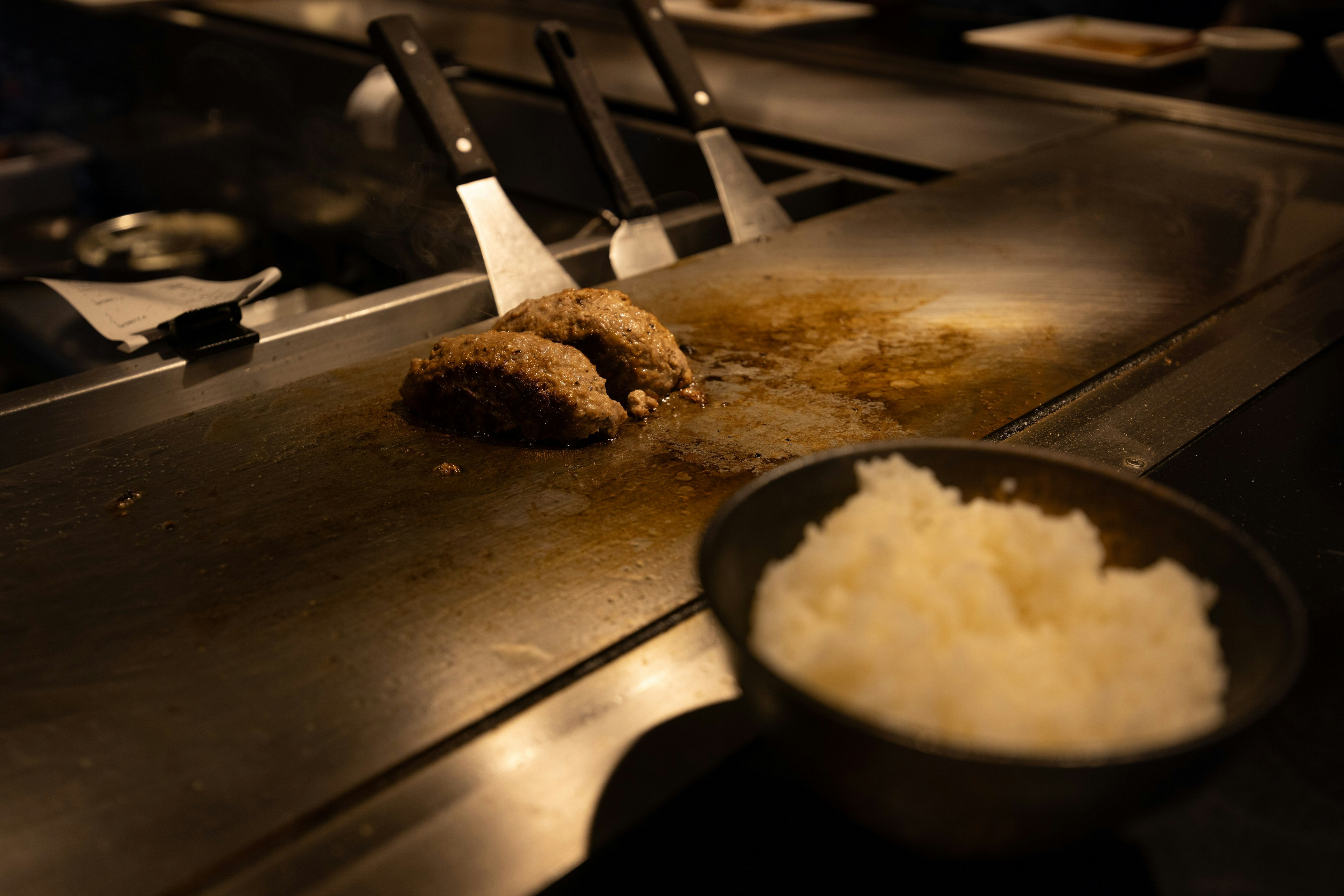 Teppanyaki-Kochszene mit gegrilltem Fleisch und weißem Reis