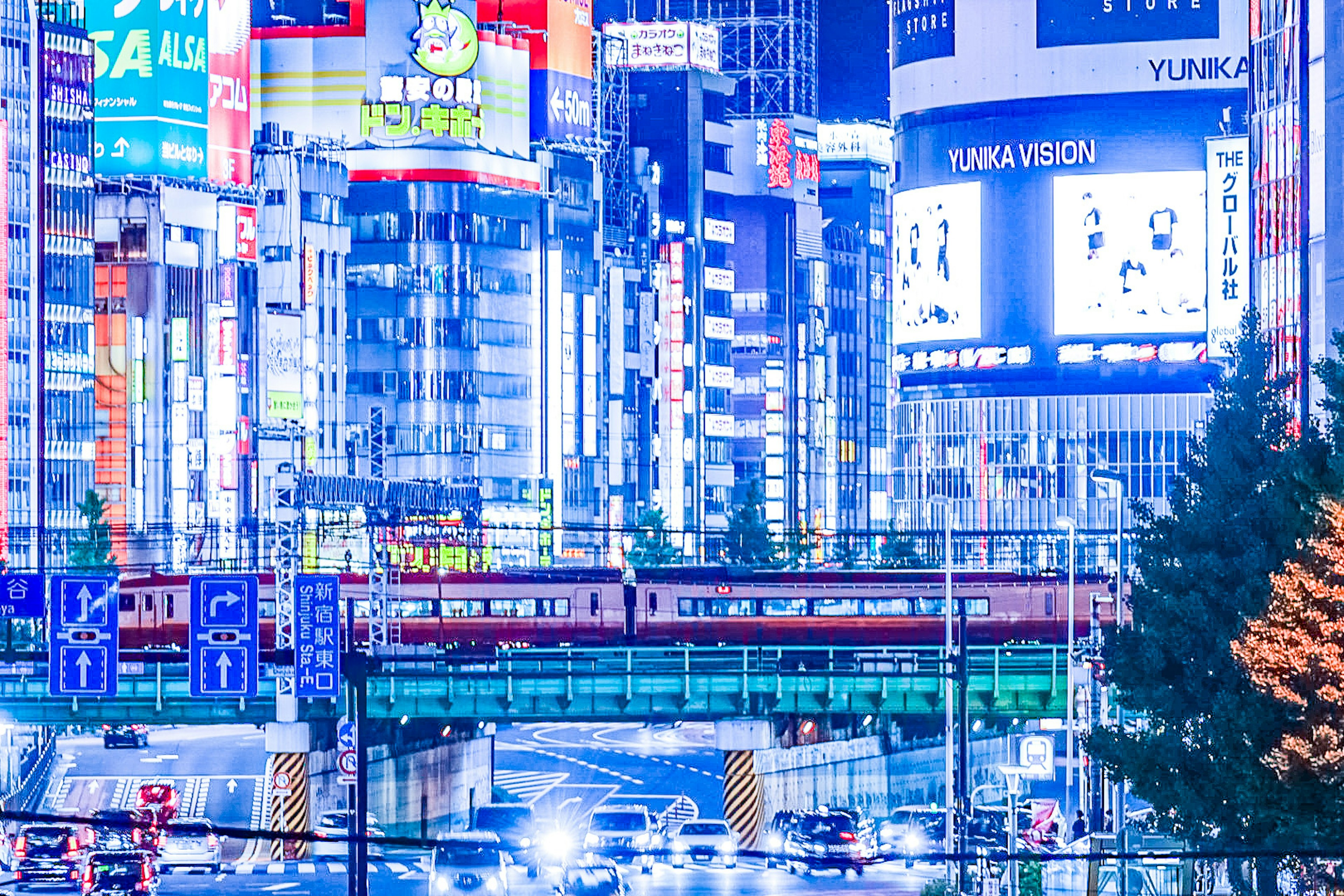 東京の夜景に輝くネオン看板と電車