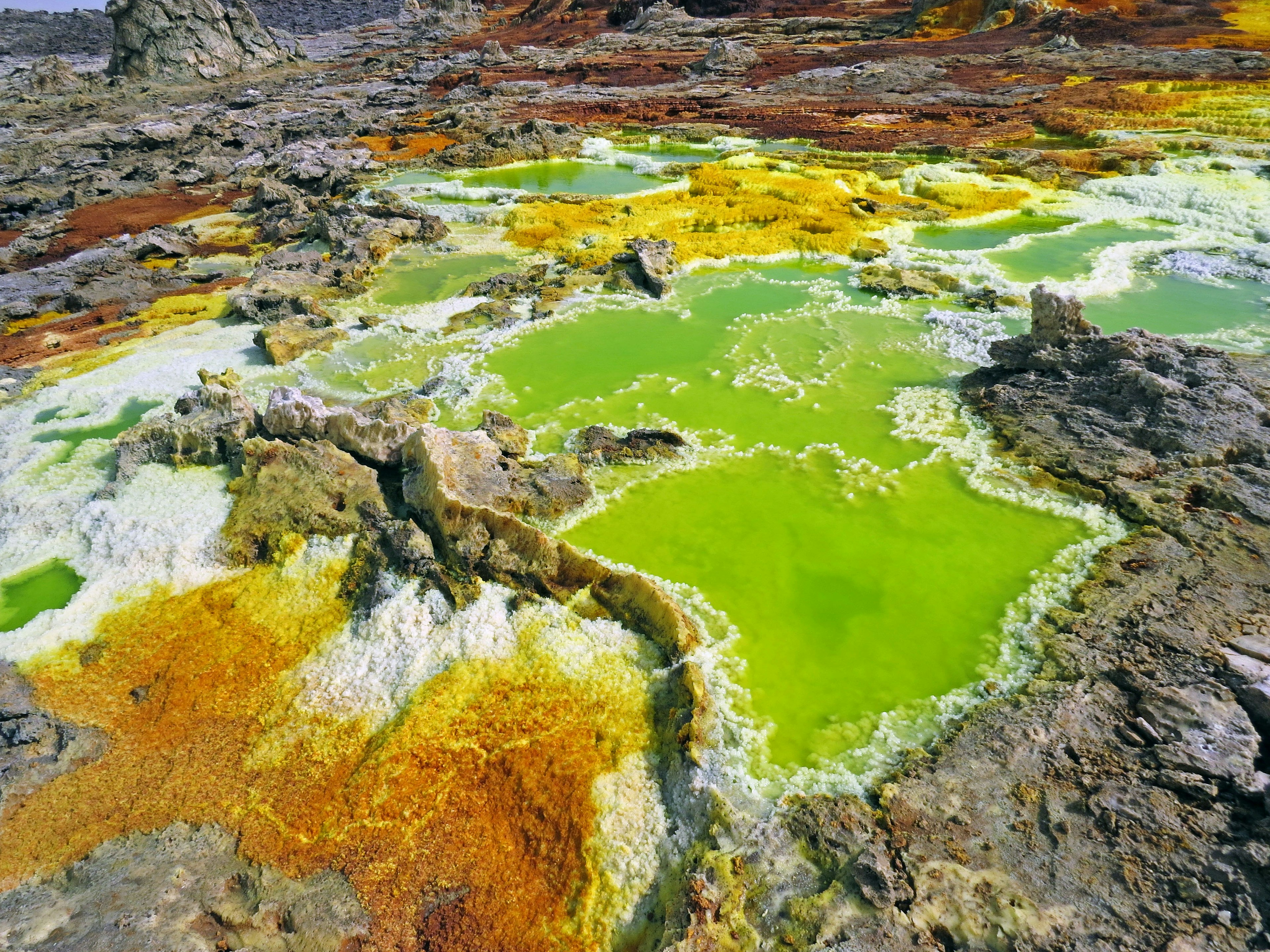 Charcas geotérmicas coloridas y rocas en un paisaje natural