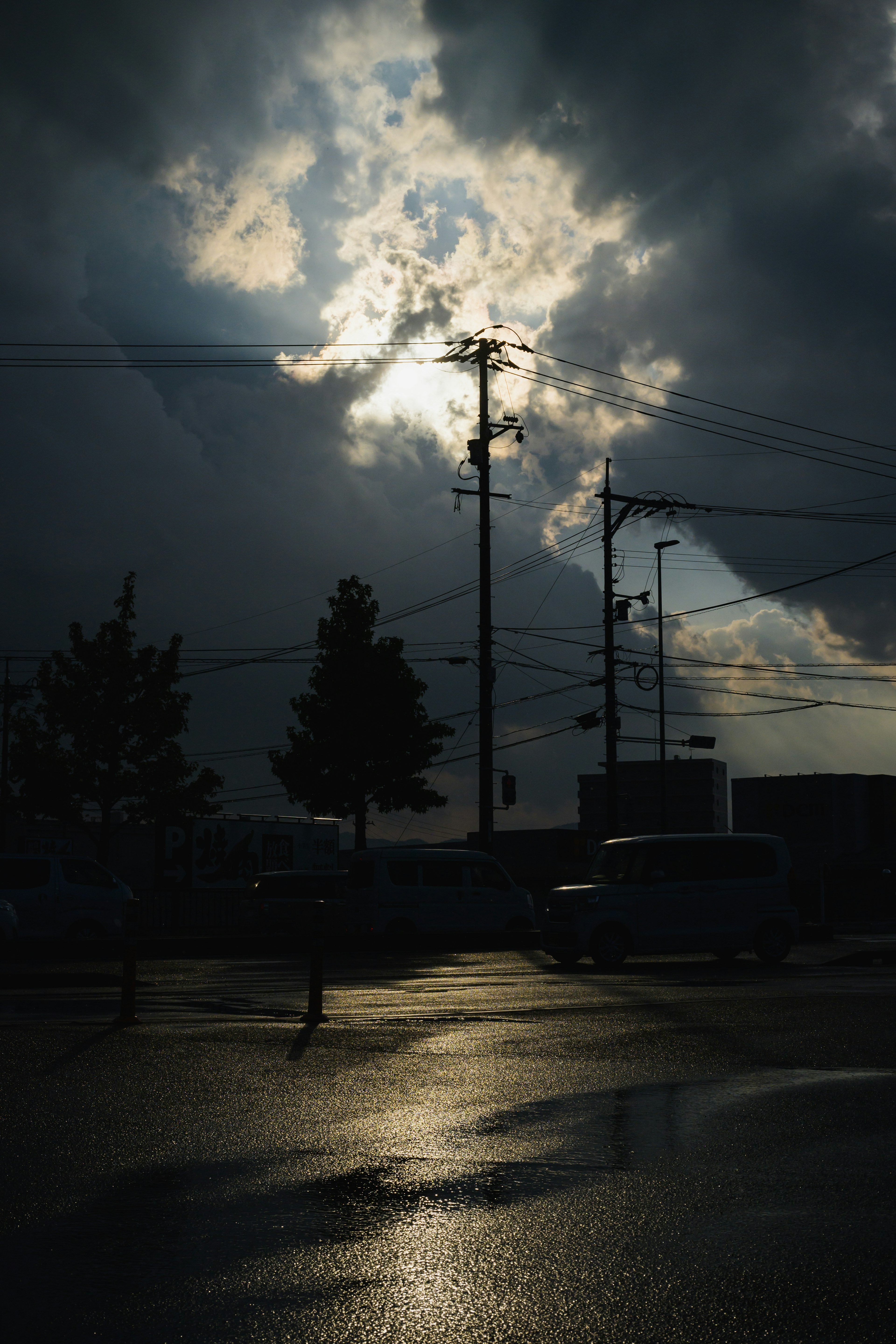 Lumière traversant des nuages sombres avec des reflets sur un pavé mouillé