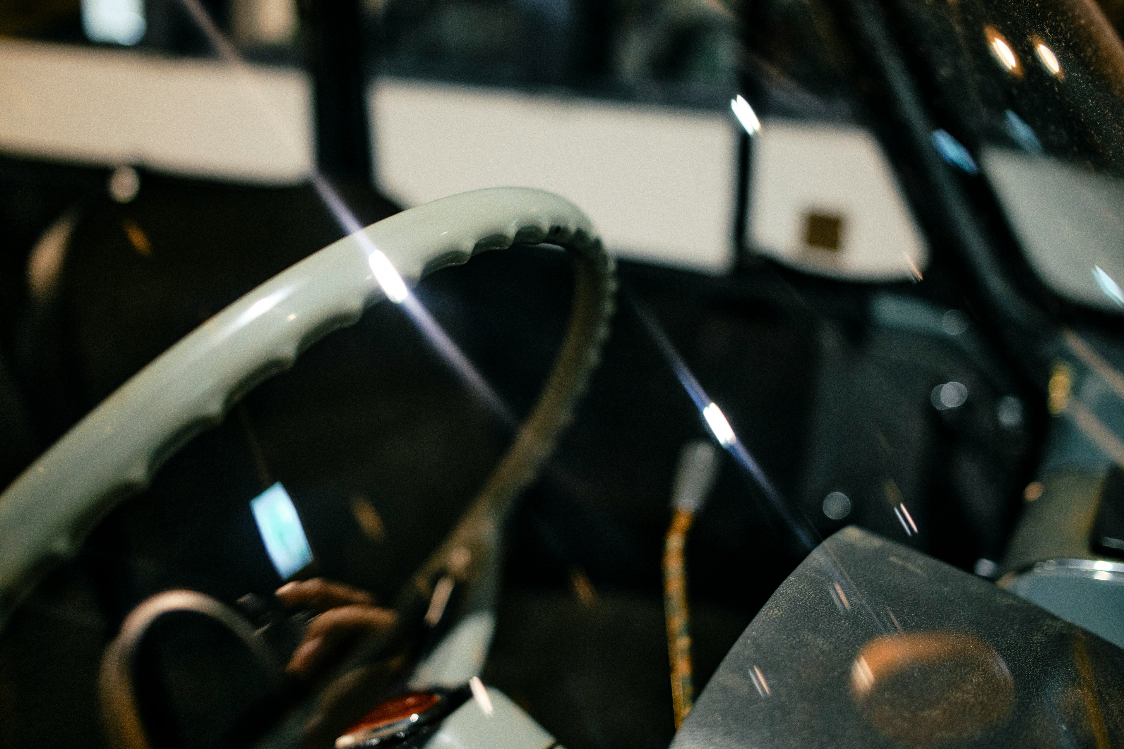 Detail of a classic car interior featuring a steering wheel and dashboard