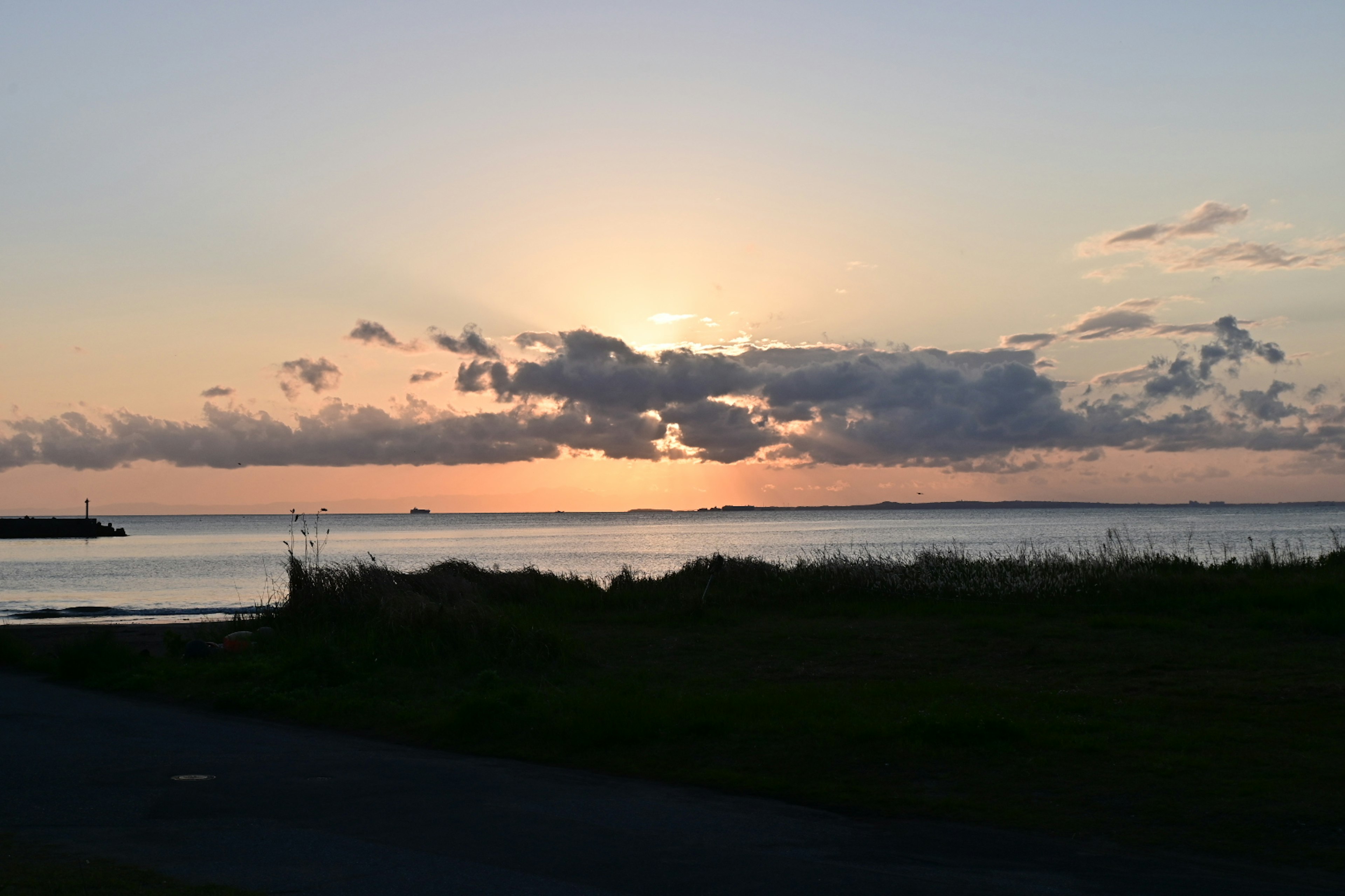 Bellissimo tramonto all'orizzonte con mare calmo e nuvole sparse