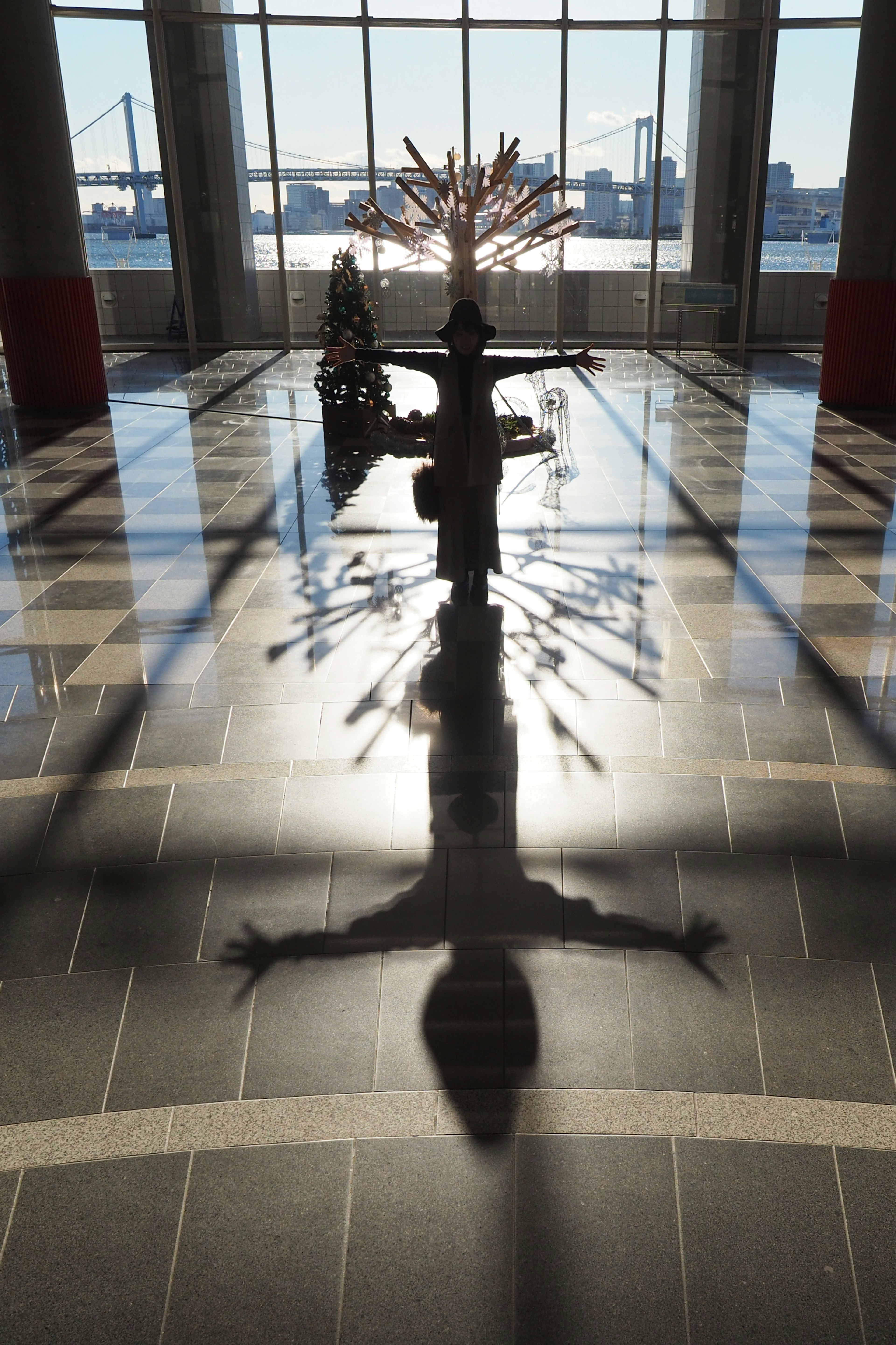 Schatten einer Skulptur, der durch das natürliche Licht großer Fenster auf den Boden fällt