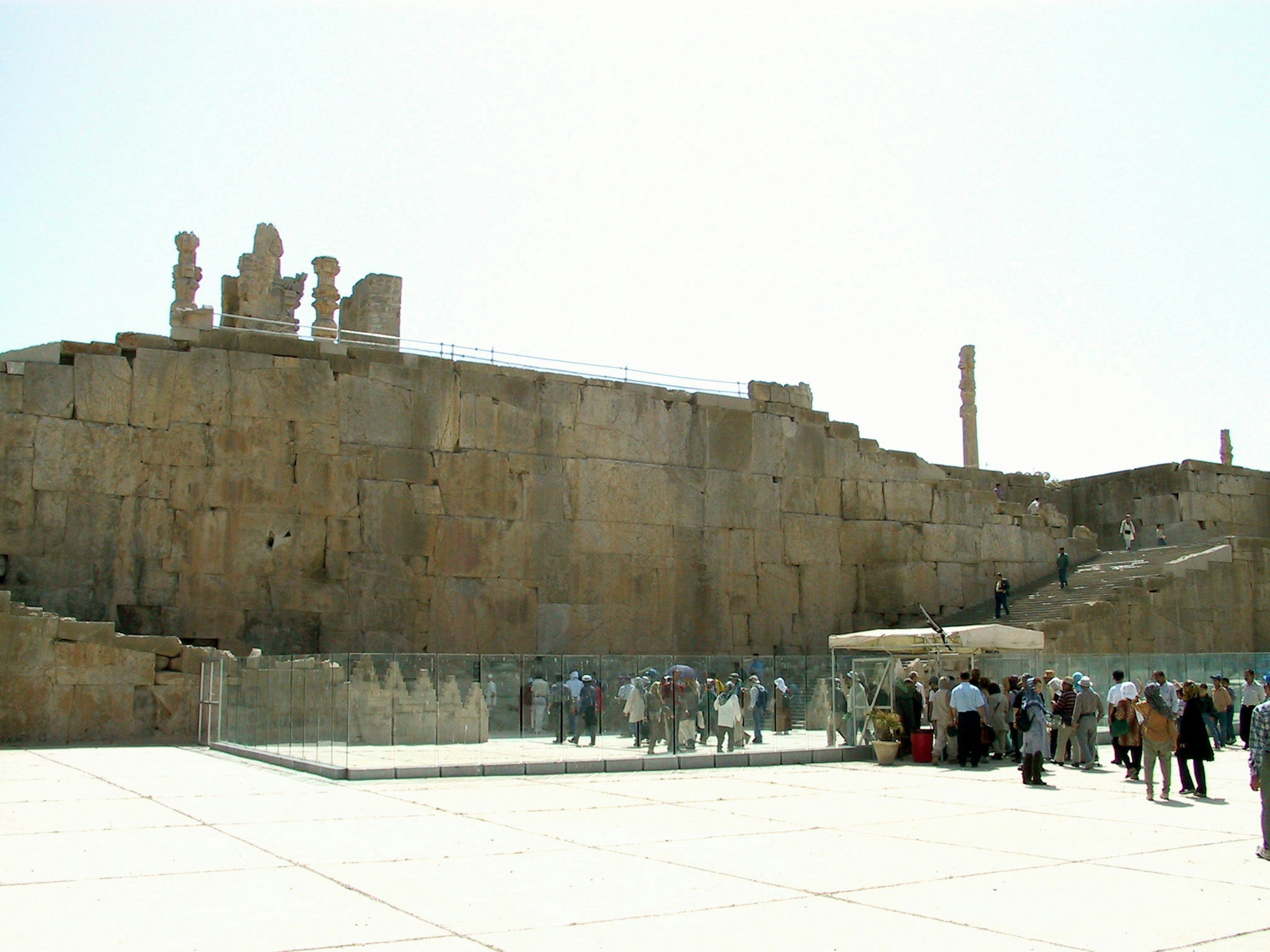 Ancient ruins featuring carved statues with visitors exploring the site