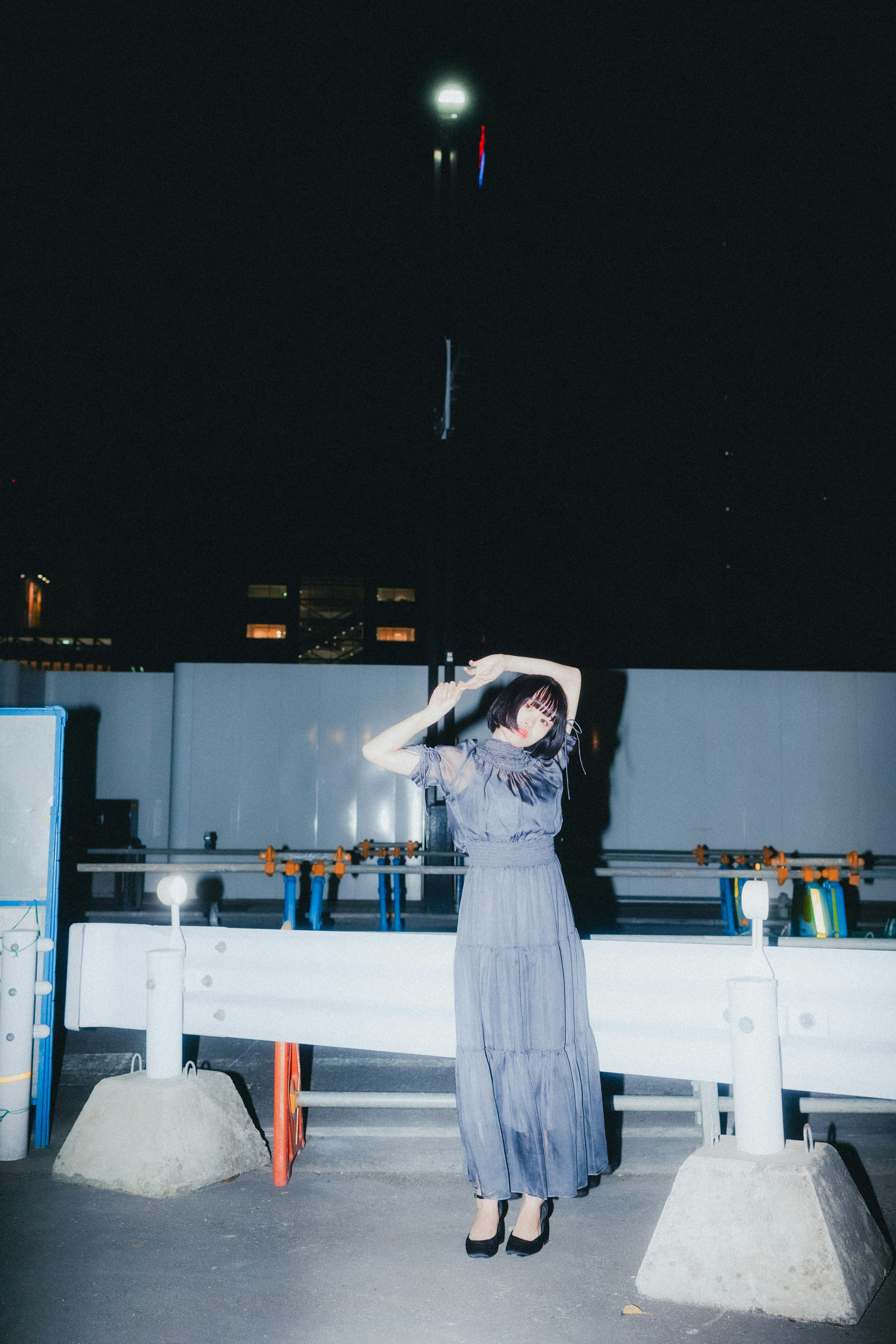 Fashion photo of a woman posing against a nighttime city backdrop