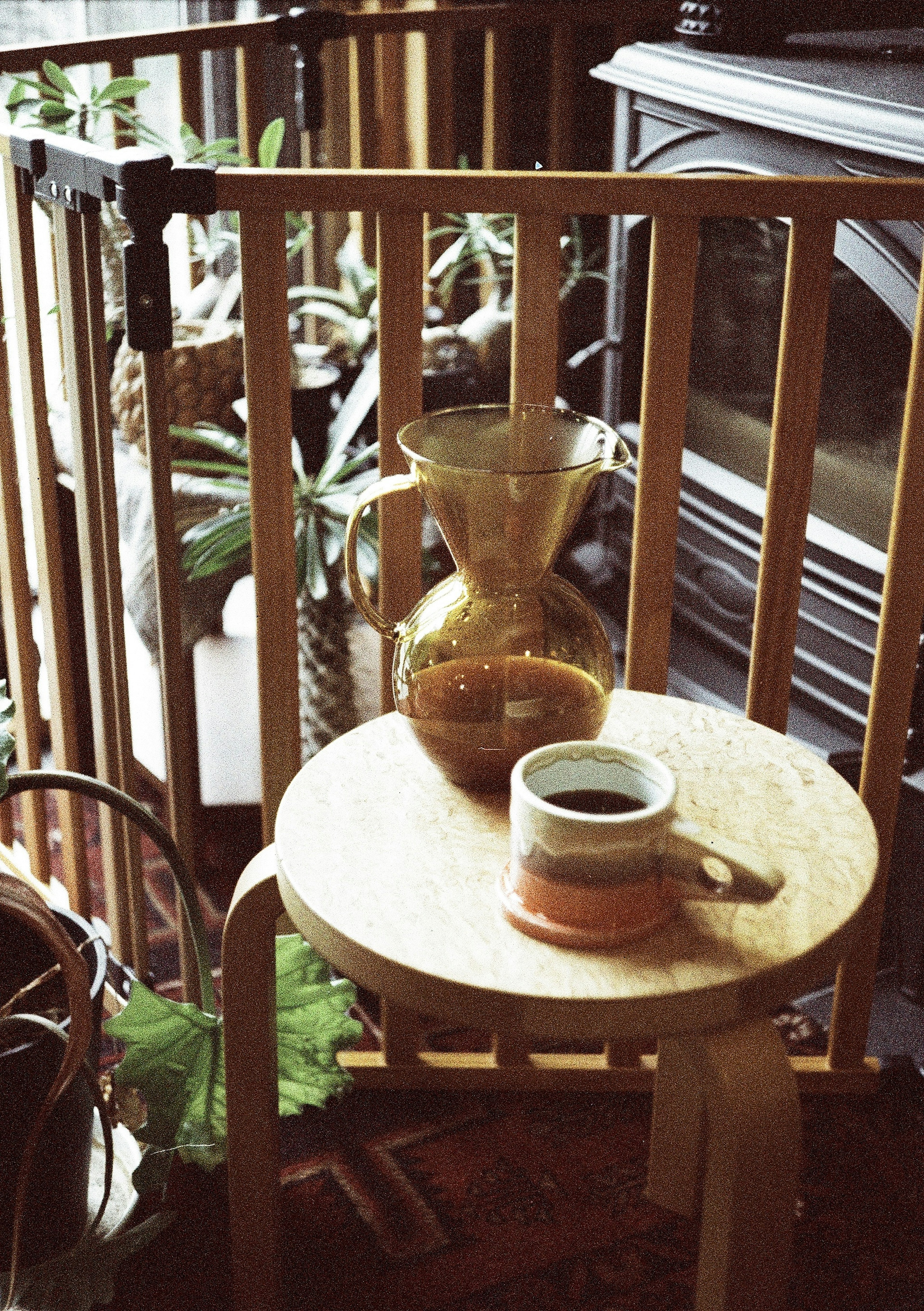 Una mesa de madera con una taza de café y una jarra dorada