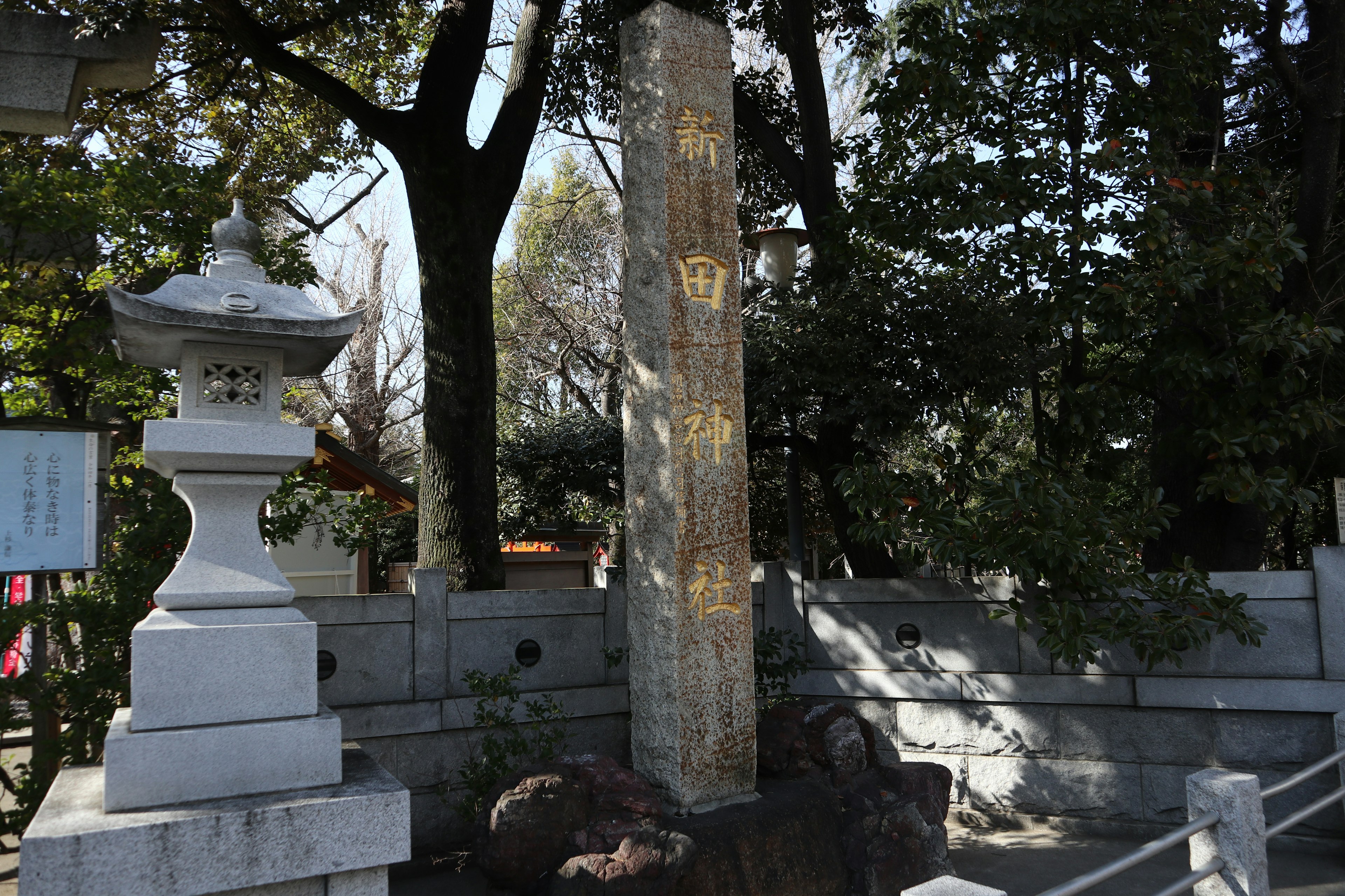 Monumento de piedra y linterna en el patio de un santuario