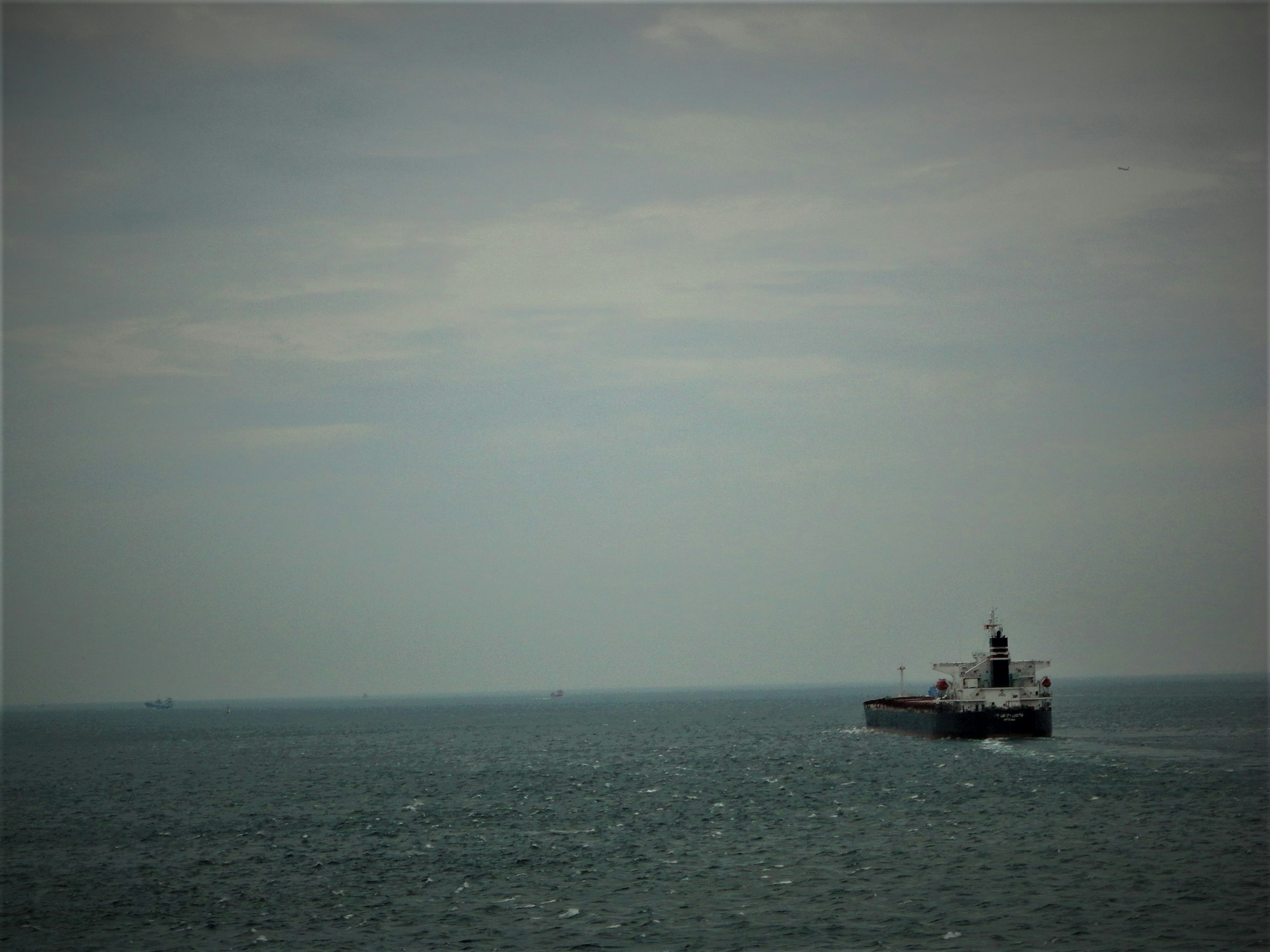 Kapal kargo di laut di bawah langit mendung