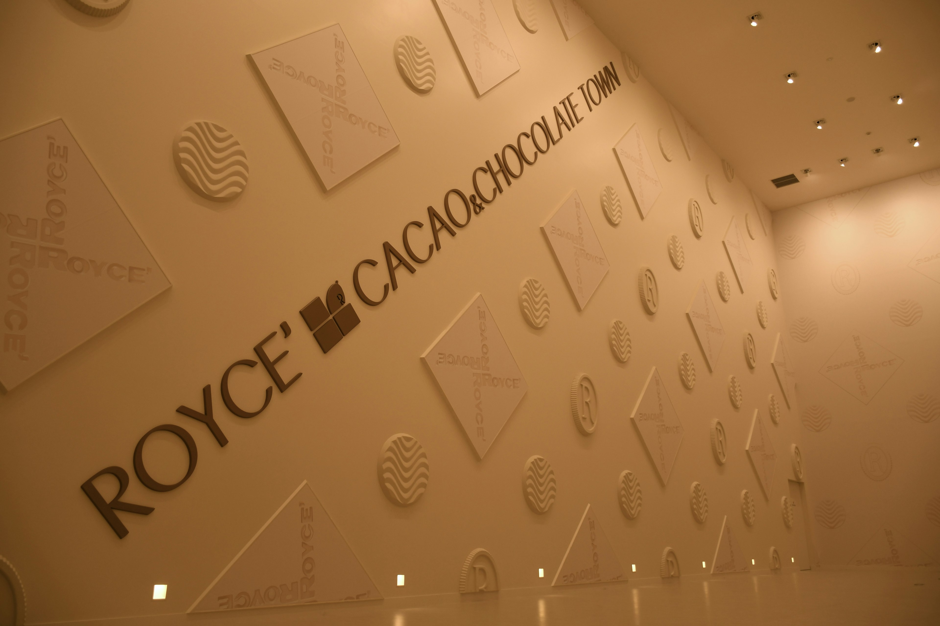 Wall design featuring Royce' Cacao Chocolatier logo and patterns