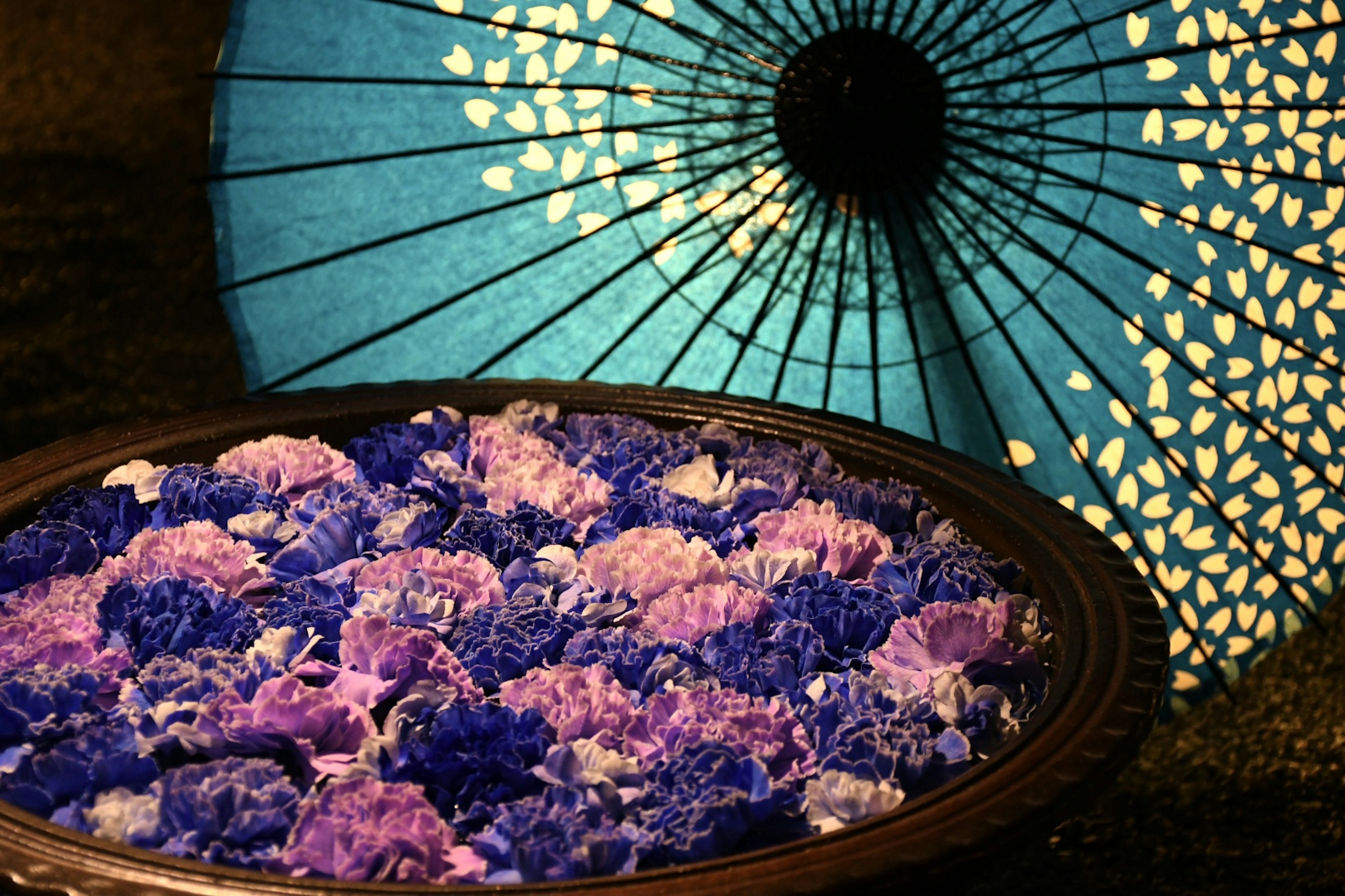 Blue Japanese umbrella and bowl of purple flowers