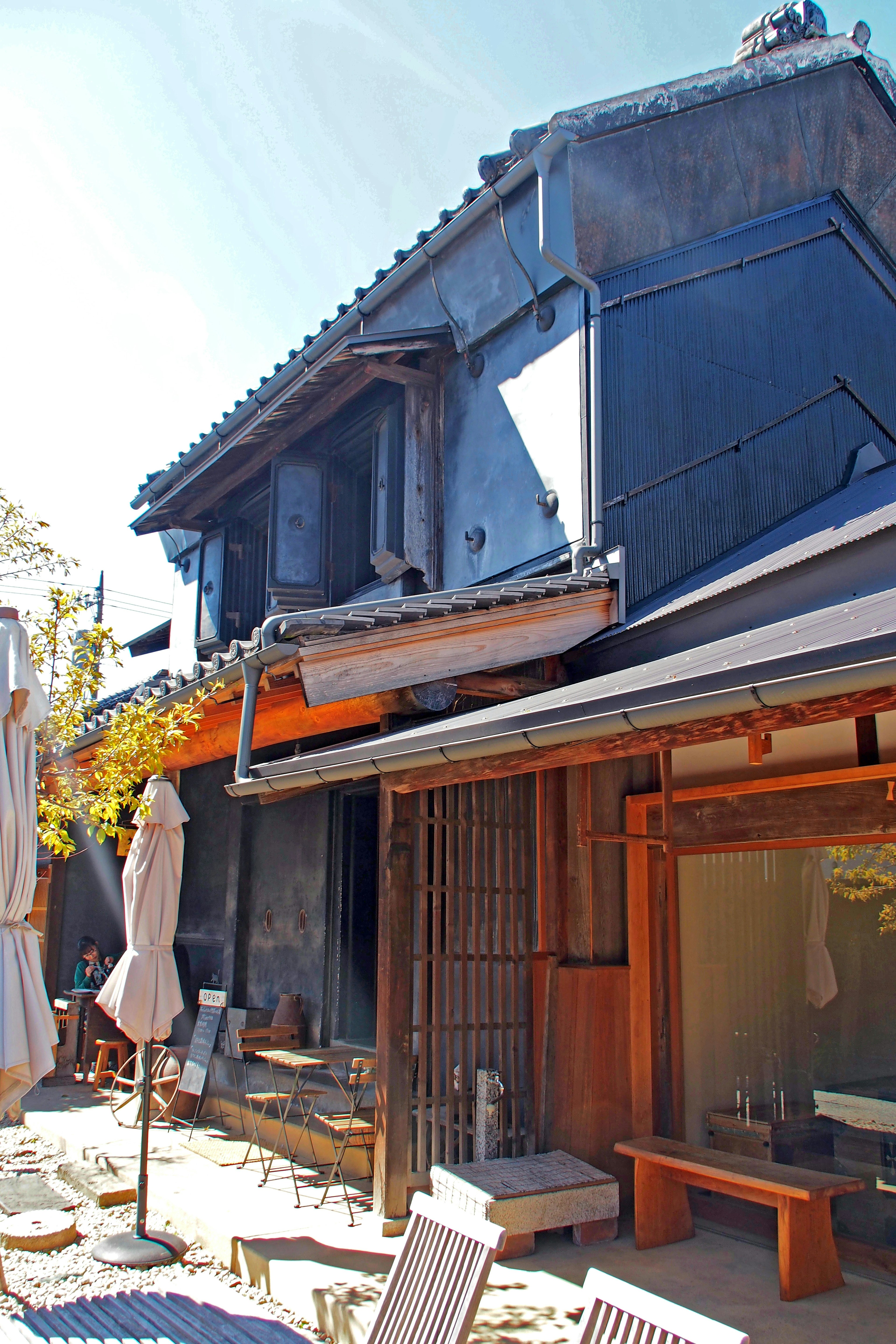 Extérieur d'un bâtiment japonais traditionnel avec un toit bleu et une structure en bois