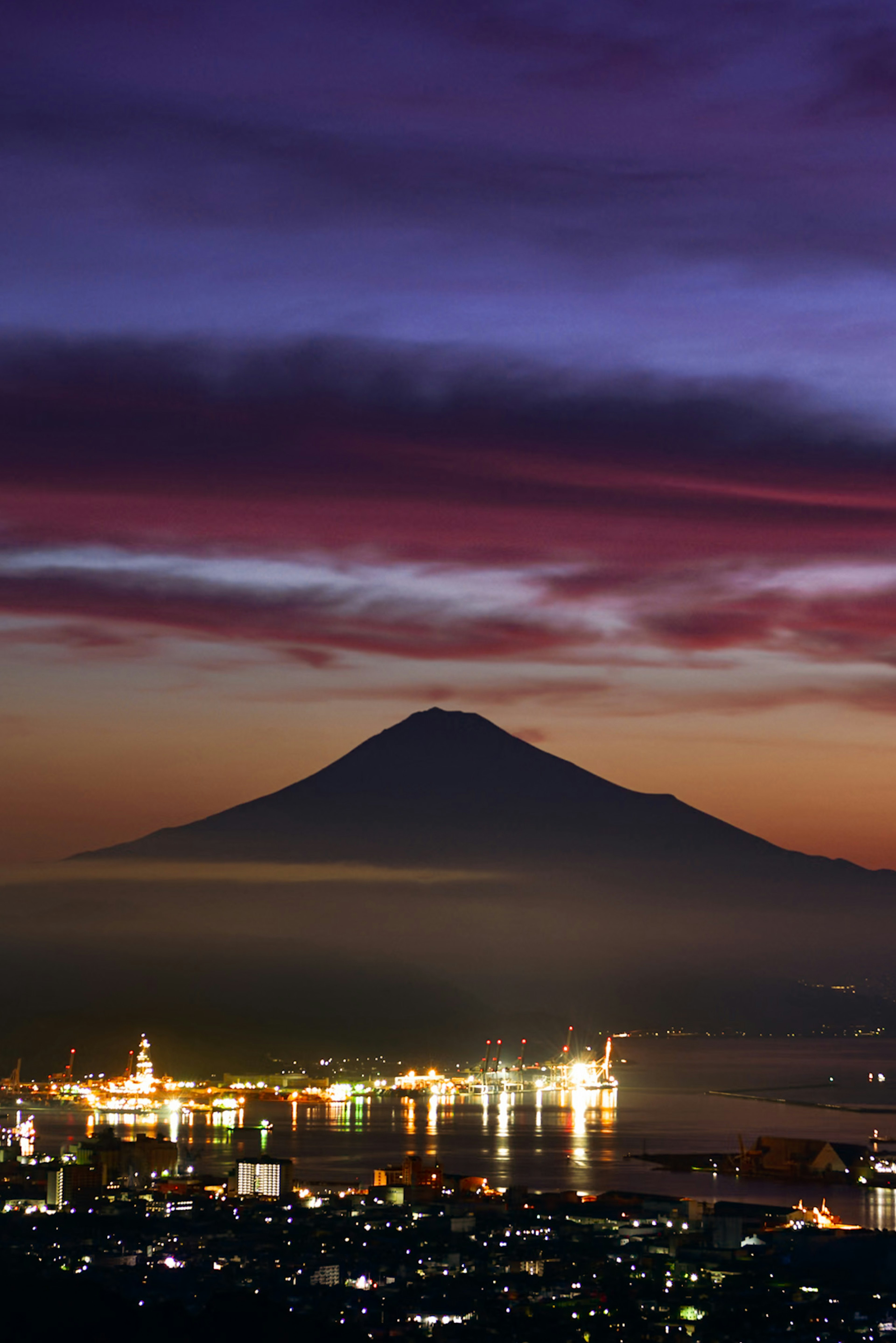 夕焼けに照らされた富士山と港の美しい景色