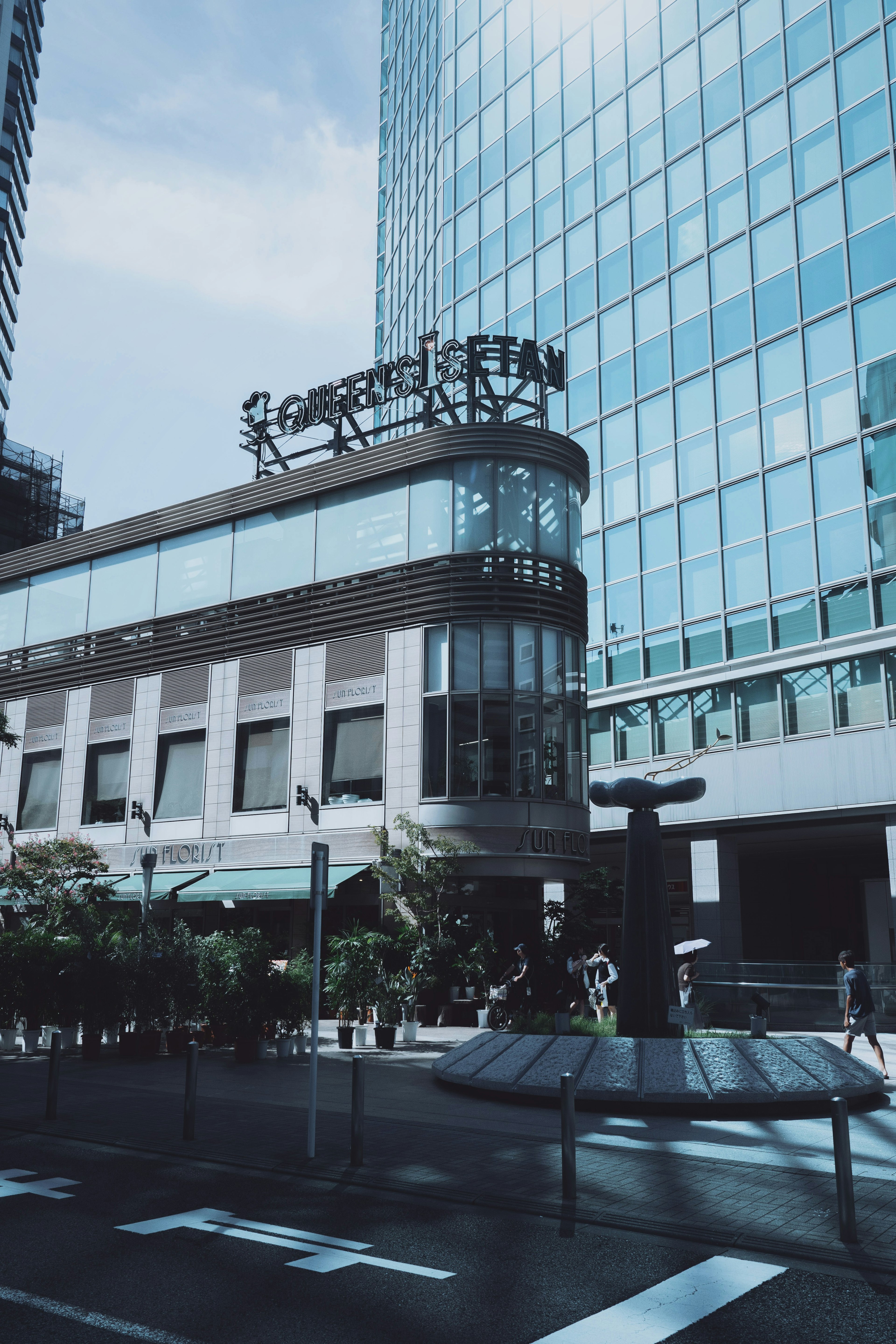 Edificio moderno con fachada de vidrio y rascacielos al fondo