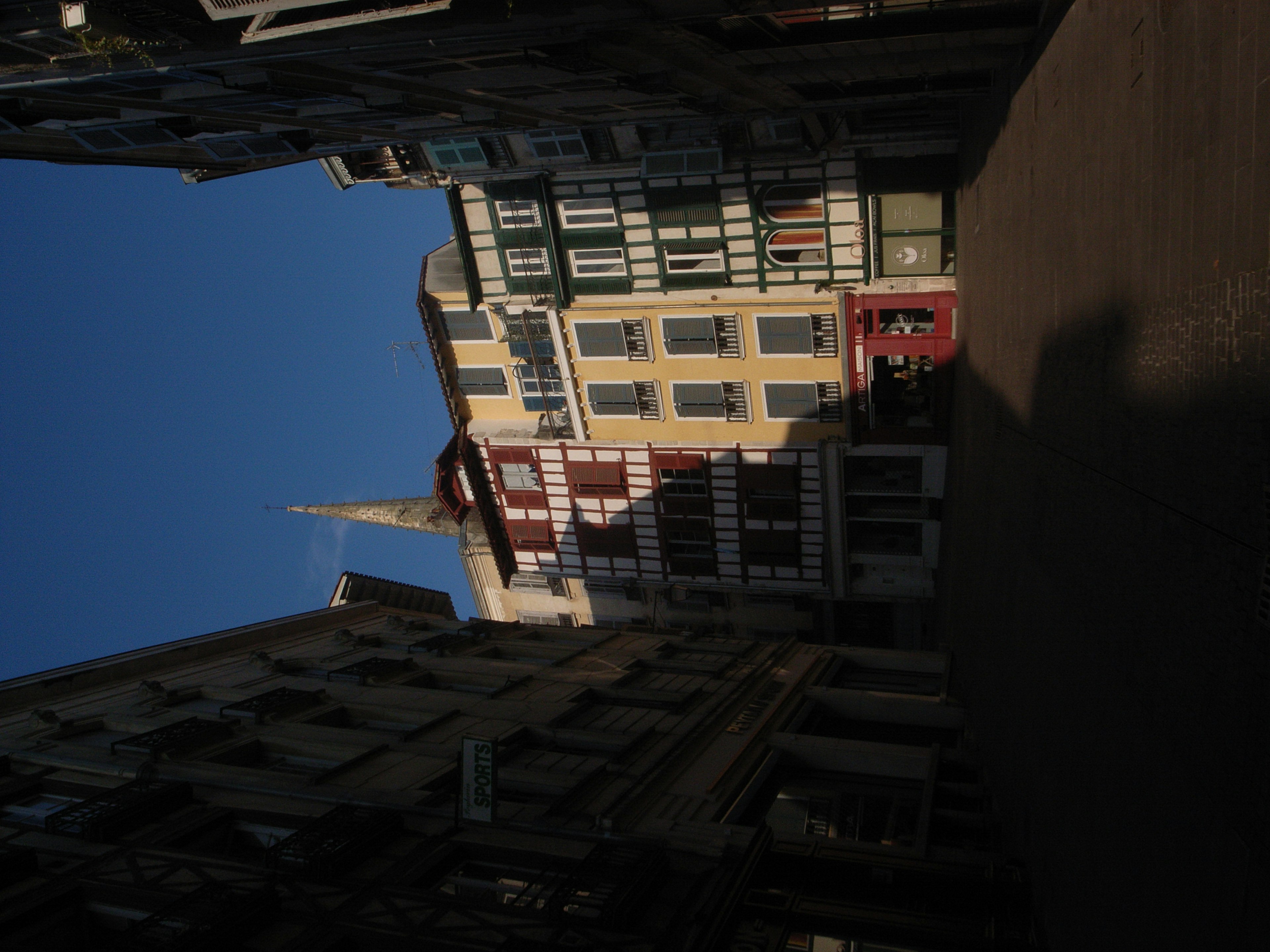 Vista de una esquina de la calle con edificios bajo un cielo azul con una puerta roja distintiva