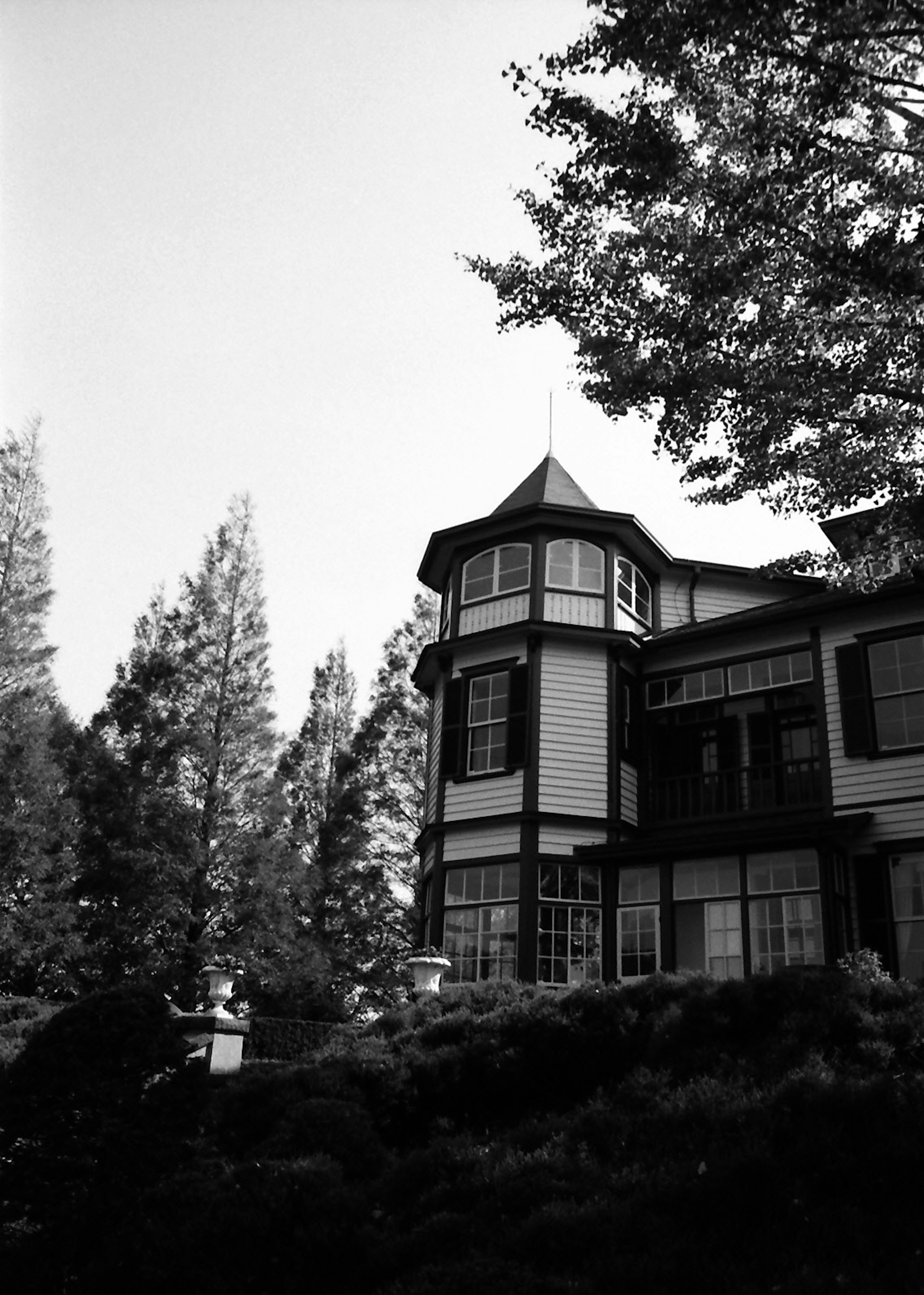 Black and white photo of an old-style house with a tower